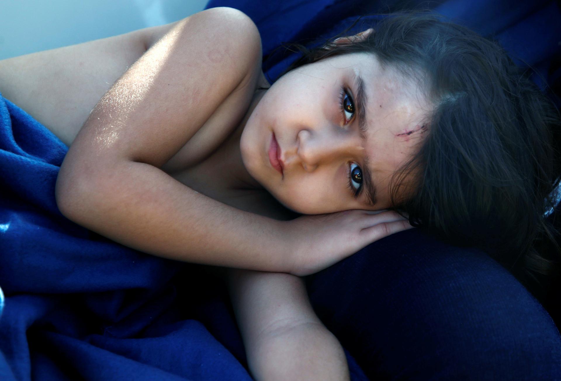 Syrian refugee girl rests inside the Spanish rescue vessel Astral after being rescued by the Spanish NGO Proactiva off the Libyan coast in the Mediterranean Sea.