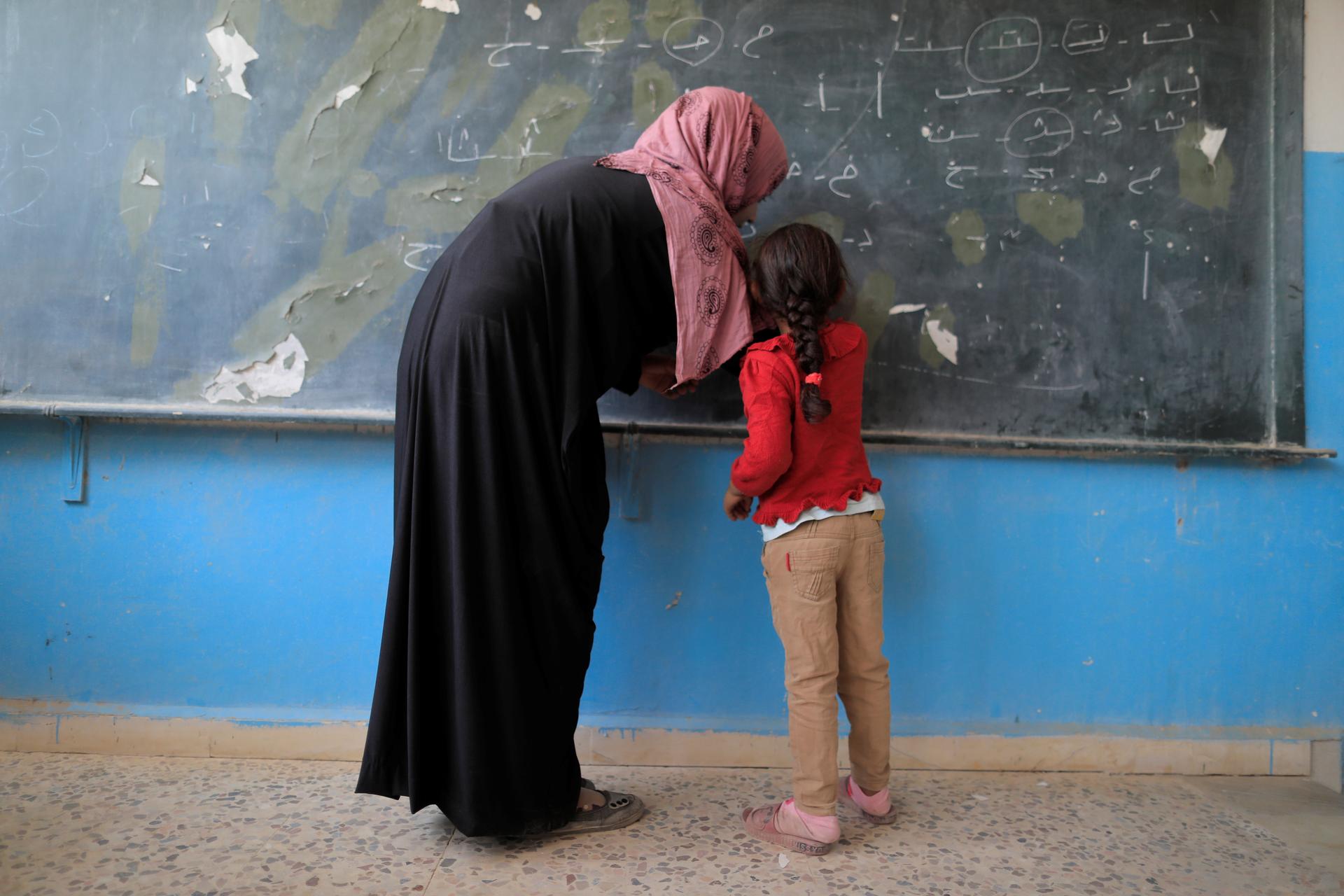 A girl attends her first class at a school in Hazema in north Raqqa, Syria.