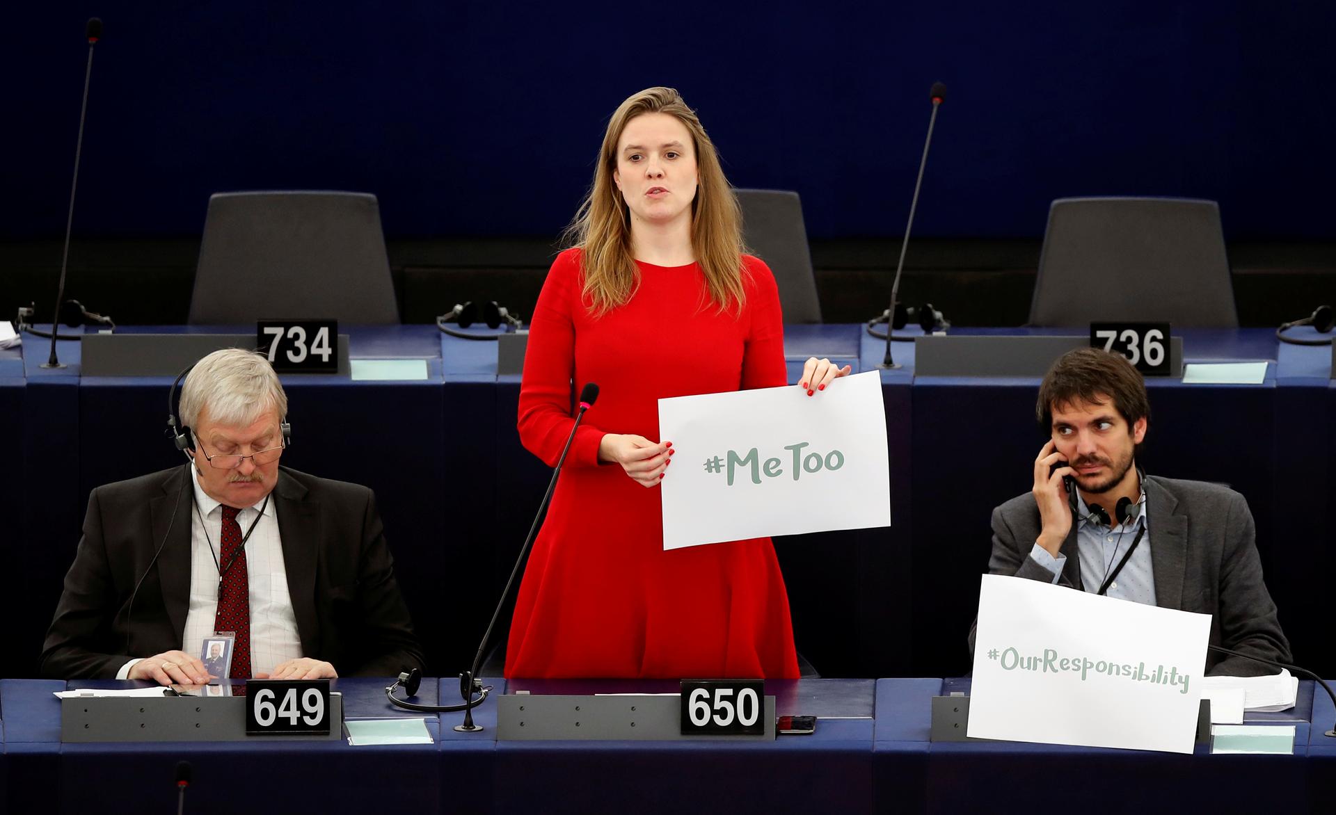European Parliament member Terry Reintke (C) holds a placard with the hashtag "MeToo" during a debate