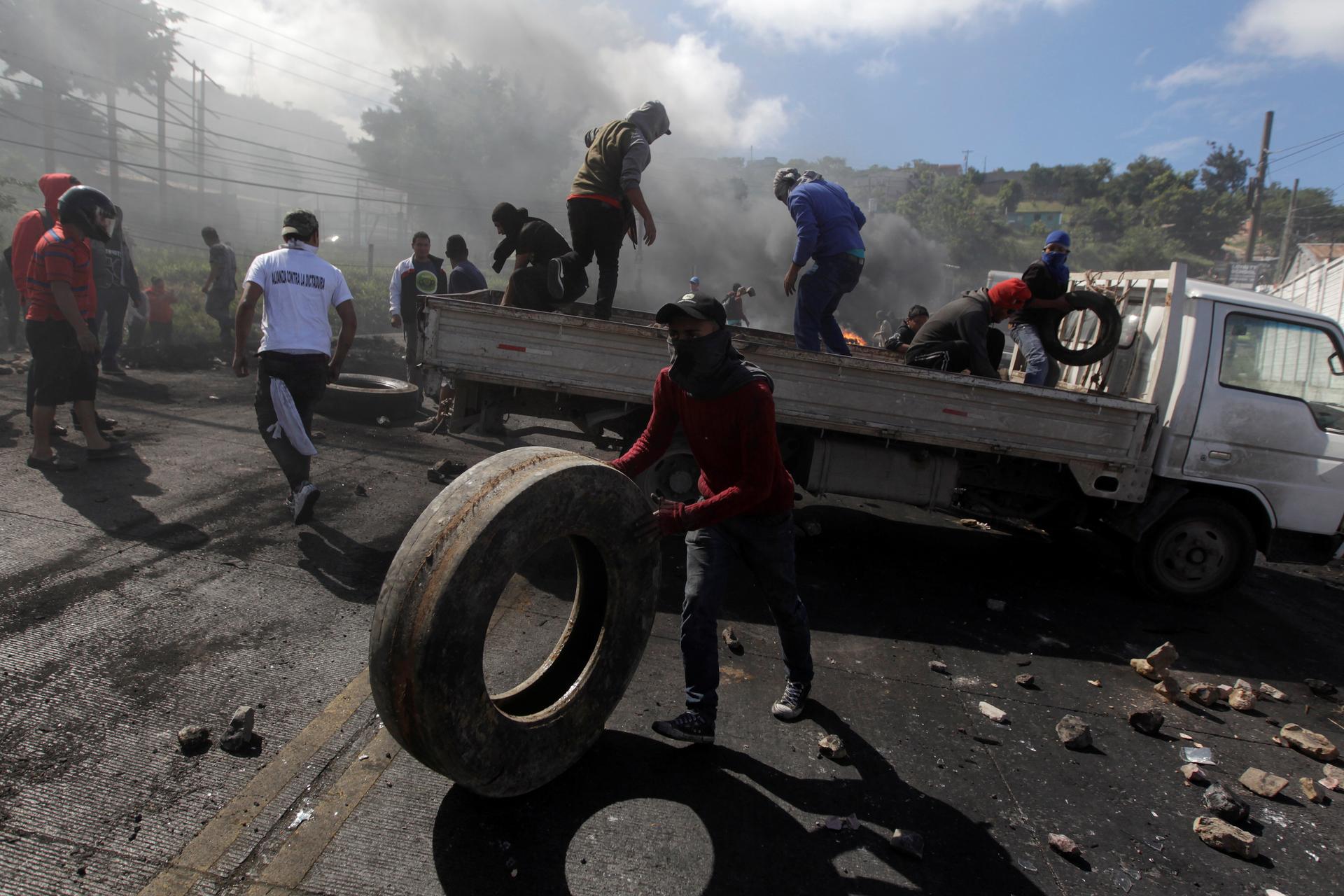 Supporters of Salvador Nasralla, presidential candidate for the Opposition Alliance Against the Dictatorship, unload a truck with rocks and tires for a barricade