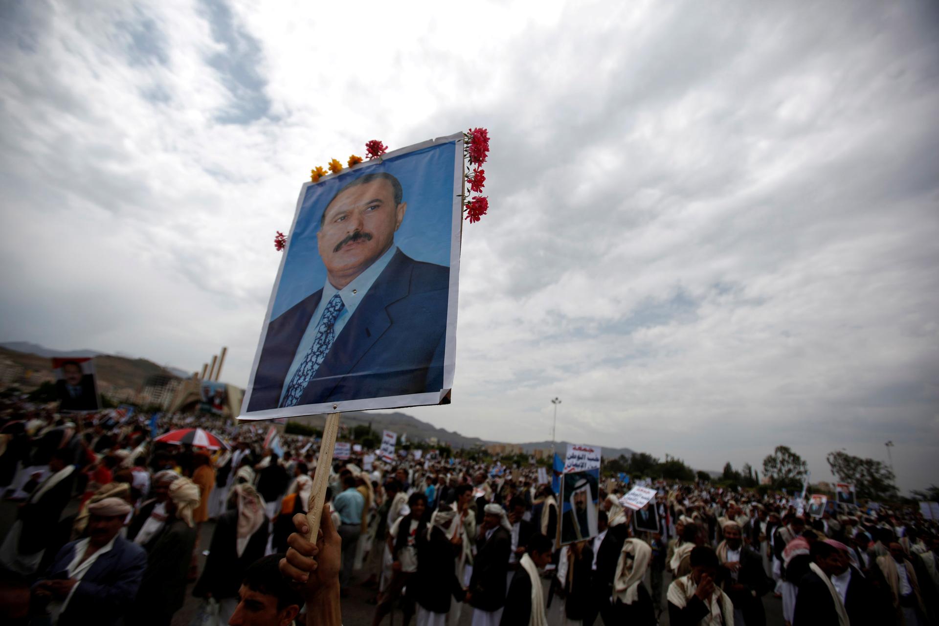  A supporter of Yemen's then President Ali Abdullah Saleh waves a poster featuring him during a rally to show support for him in Sanaa