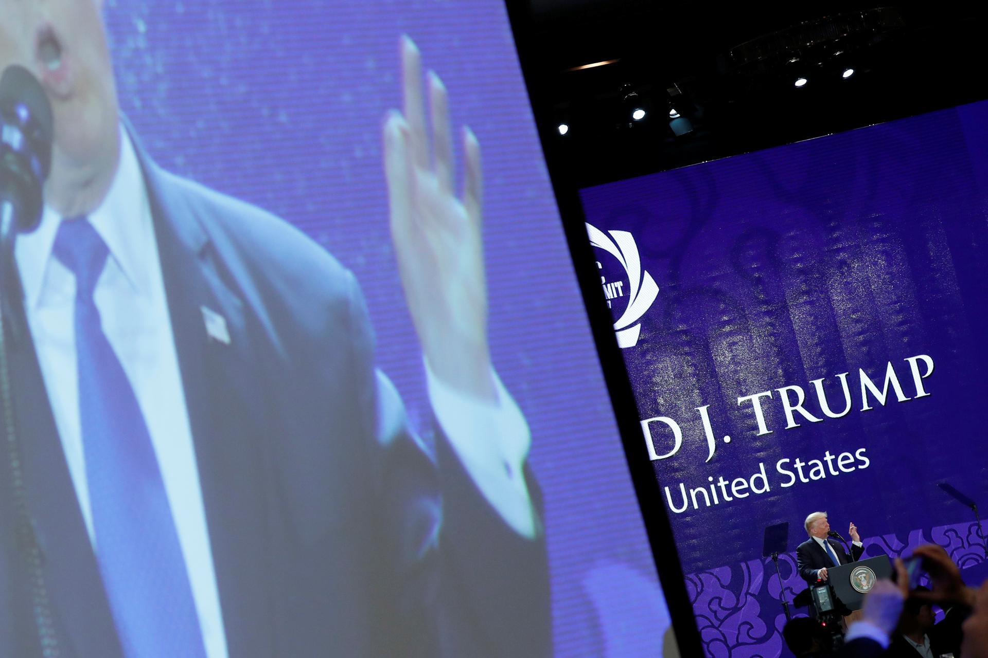 President Donald Trump appears on a large video screen as he delivers remarks at the APEC CEO Summit, Nov. 10, 2017.