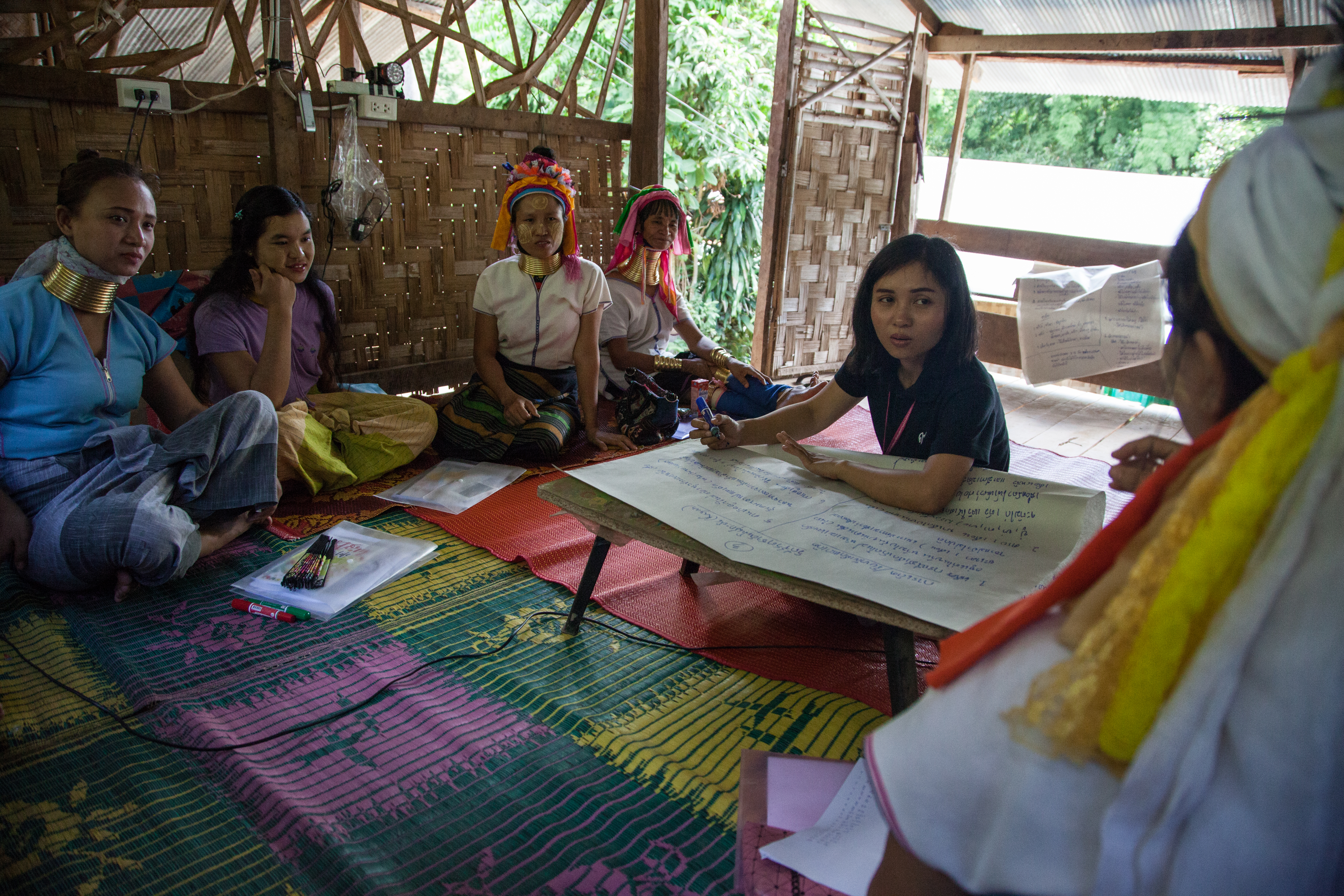 Women at Huai Sua Tao gather in a communal bamboo house for a meeting with province officials who came to gather information about their culture for educational purposes.