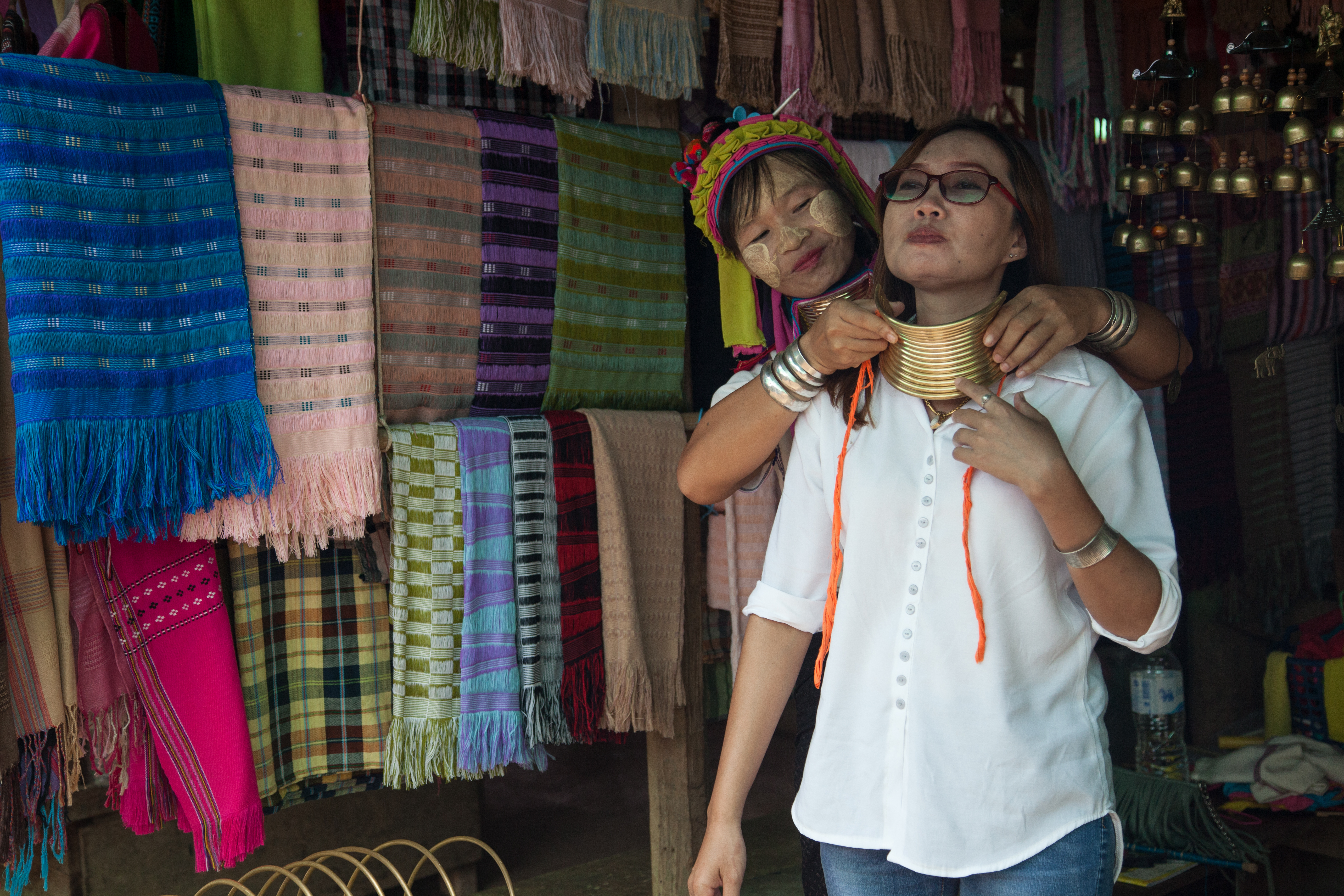 A Thai tourist tries on the brass rings that the Kayah women of Huai Sua Tao traditionally wear starting in childhood.