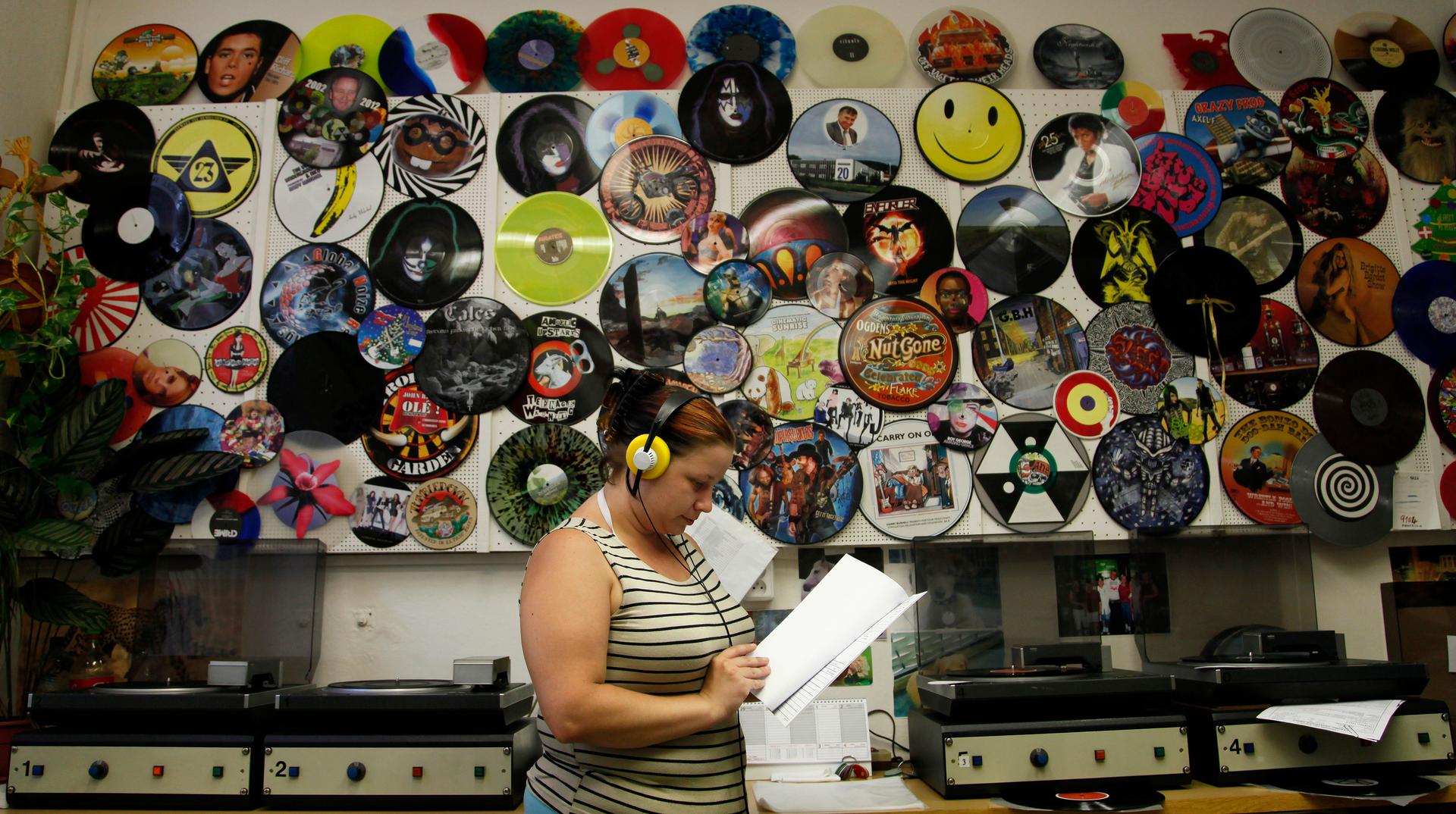 Employee Petra Kottova checks the sound quality of a pressed vinyl record at the GZ Media factory in Lodenice August 1, 2013