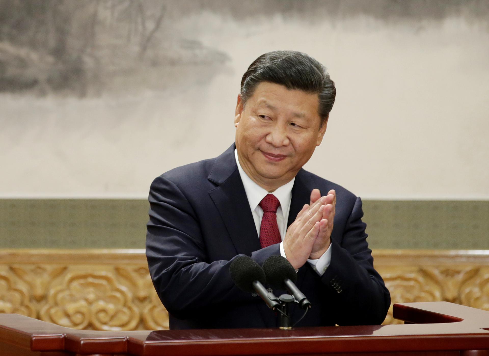 China's President Xi Jinping claps after his speech as he and other new Politburo Standing Committee members meet with the press at the Great Hall of the People in Beijing, Oct. 25, 2017.