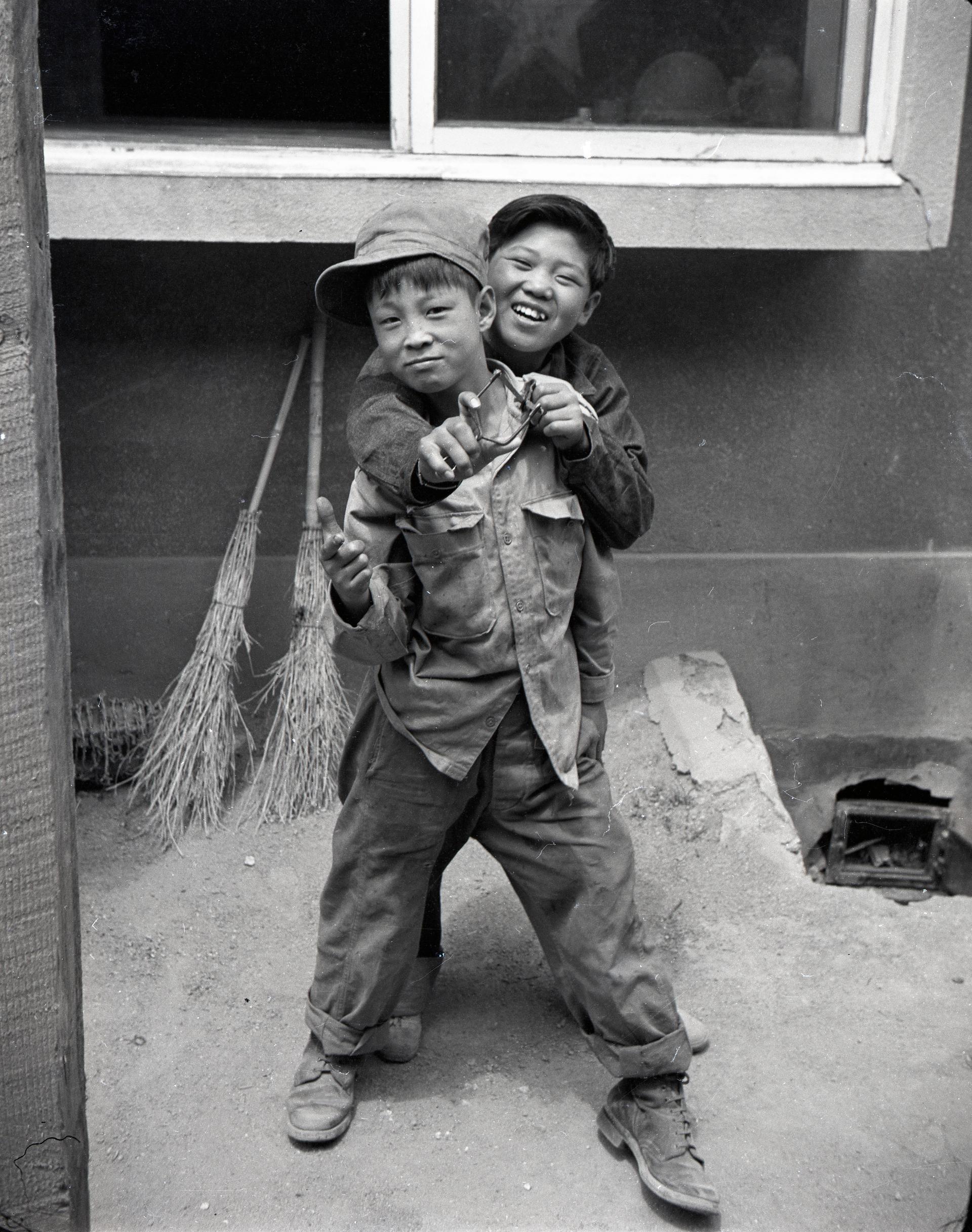 Two young houseboys pose for the camera during the Korean War.