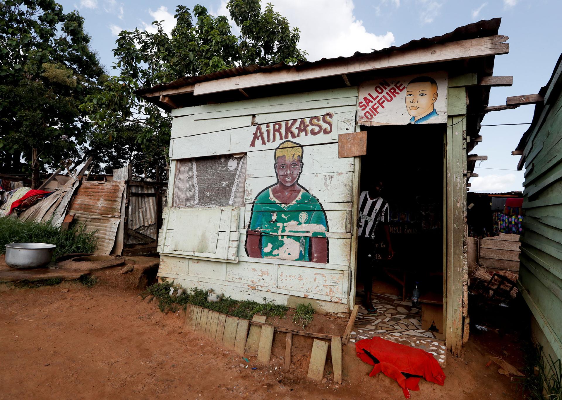 A small wooden building is shown with a painting of a soccer player on the wall.