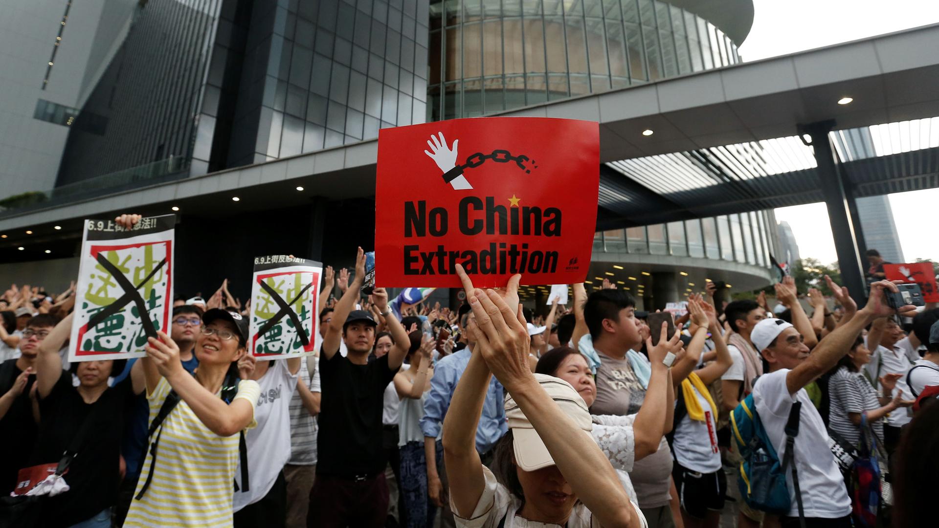 Thousand of people are shown in the streets of Hong Kong with several holding placards.