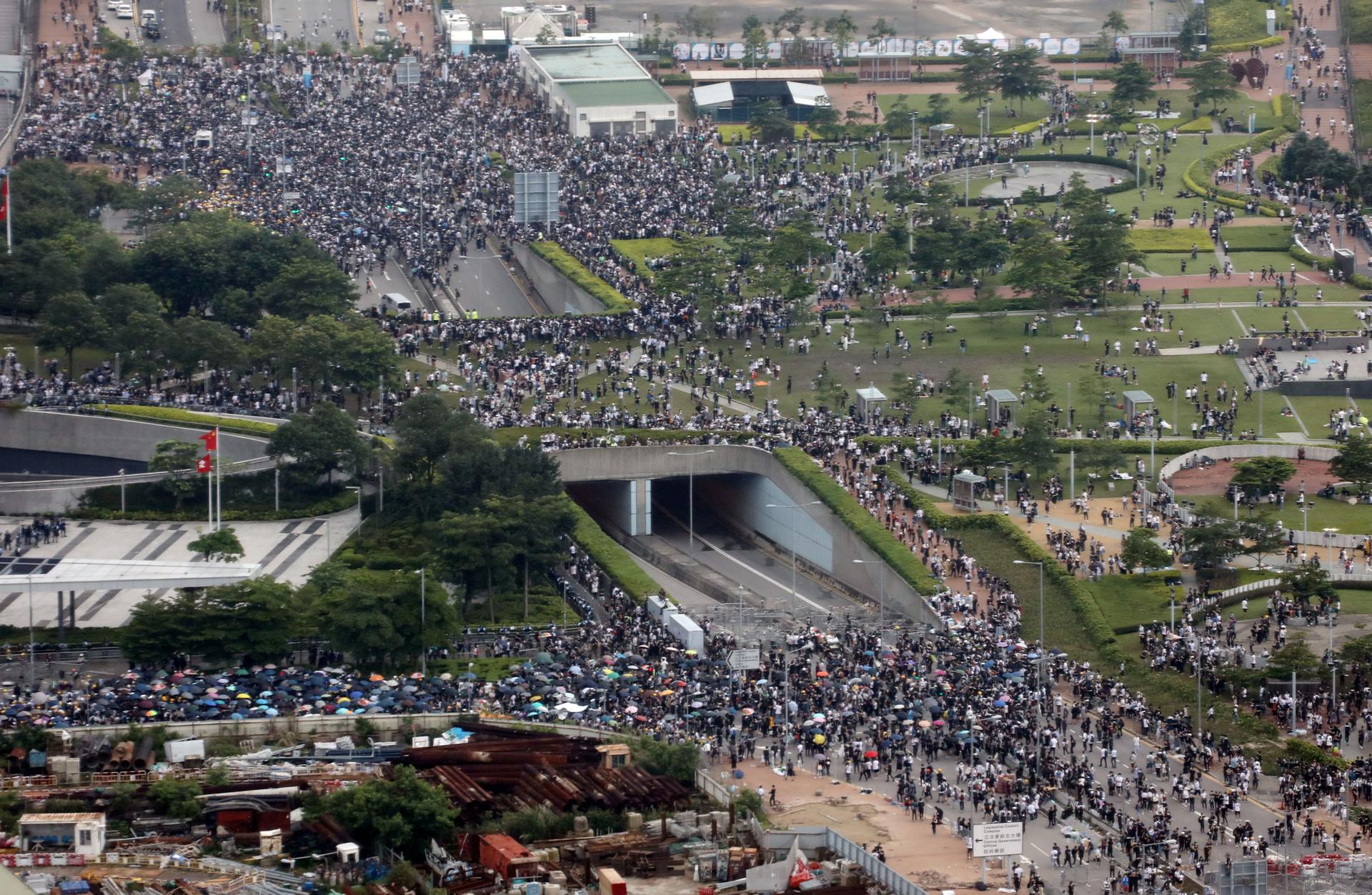 Thousands of demonstrators are shown crowding a main road in Hong Kong in a photo taking from several stories up through a window.