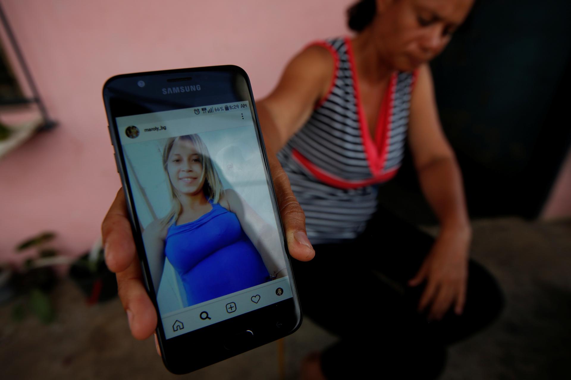 a mother shows a picture of her missing daughter