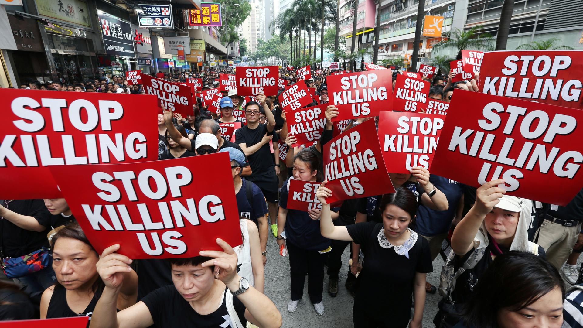 Protesters hold placards as they attend a demonstration demanding Hong Kong's leaders to step down and withdraw the extradition bill, in Hong Kong, China, June 16, 2019.
