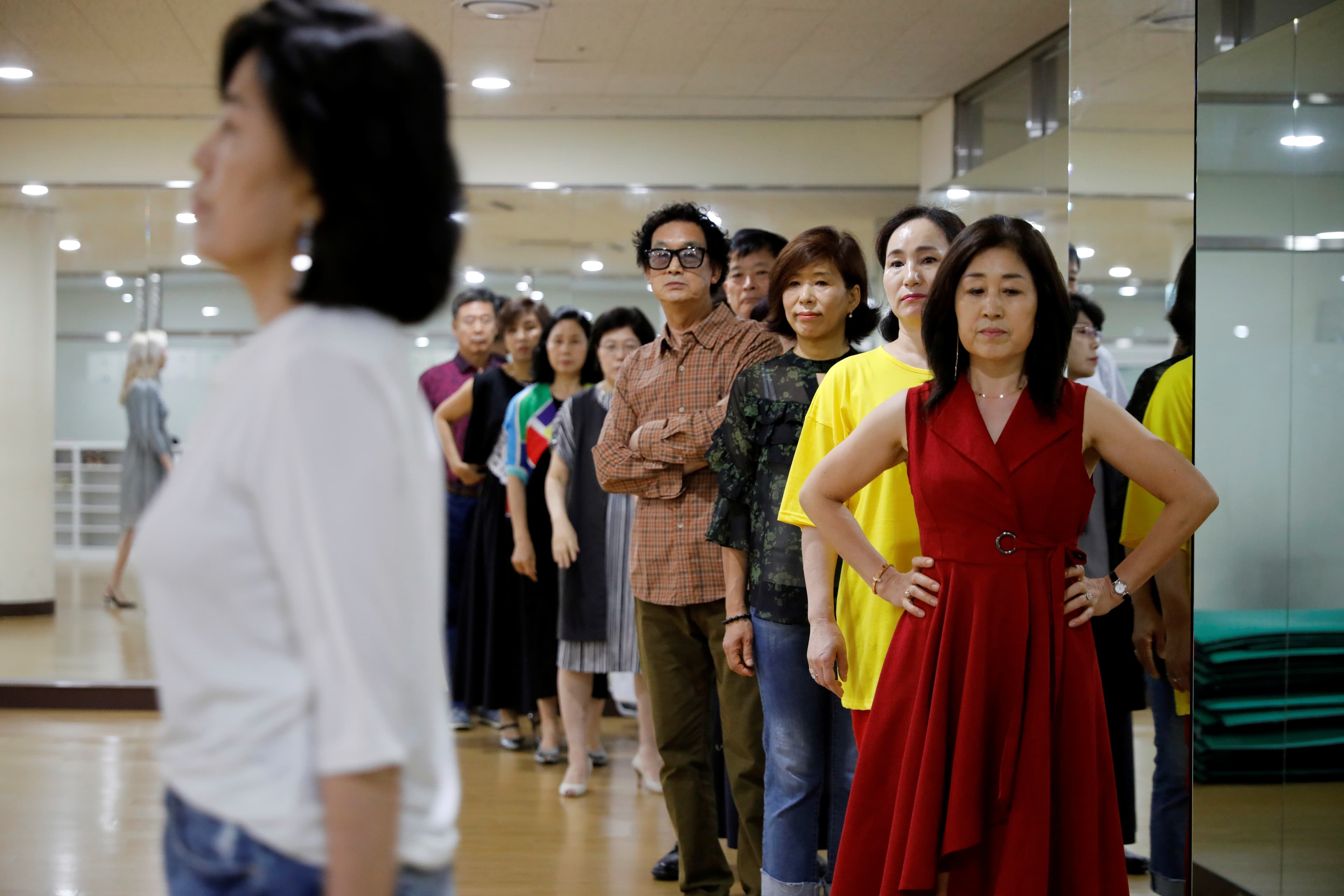 middle-aged people learning how to be models on the catwalk
