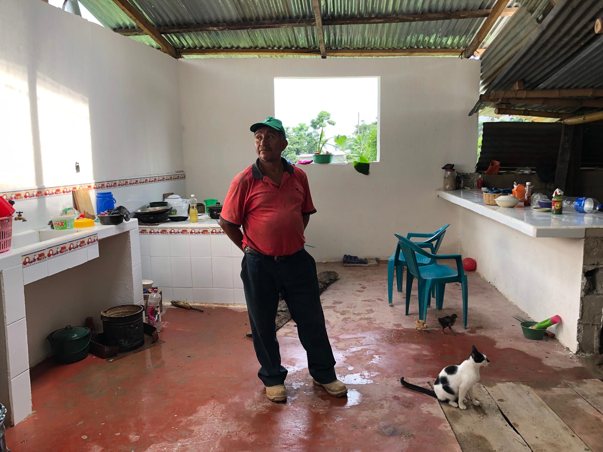 A man stands inside a newly built house in Guatemala built with remittance money from his son, who lives and works in the US. 