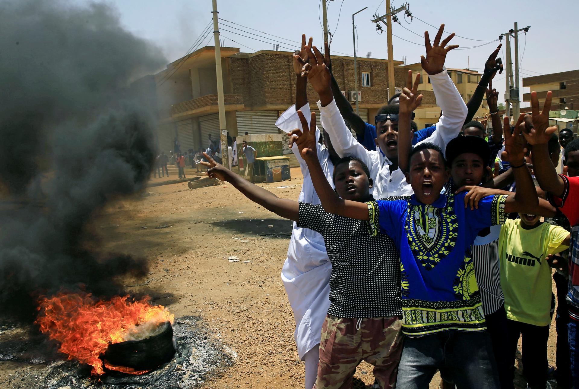 Sudanese protesters gesture and chant slogans at a barricade along a street, demanding that the country's Transitional Military Council hand over power to civilians, in Khartoum, Sudan June 5, 2019