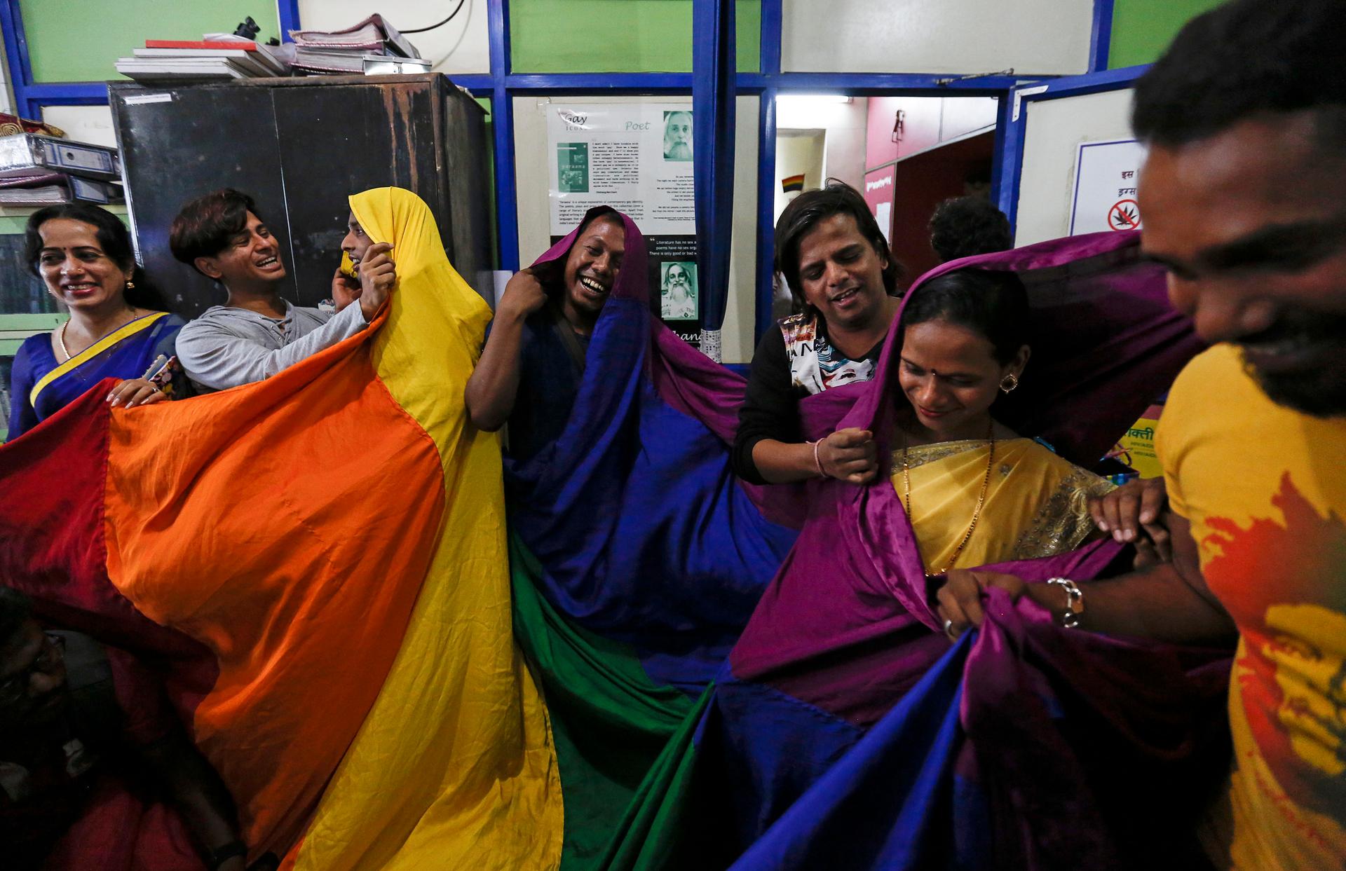 Gay rights activists in India celebrate and cover themselves in rainbow flags.