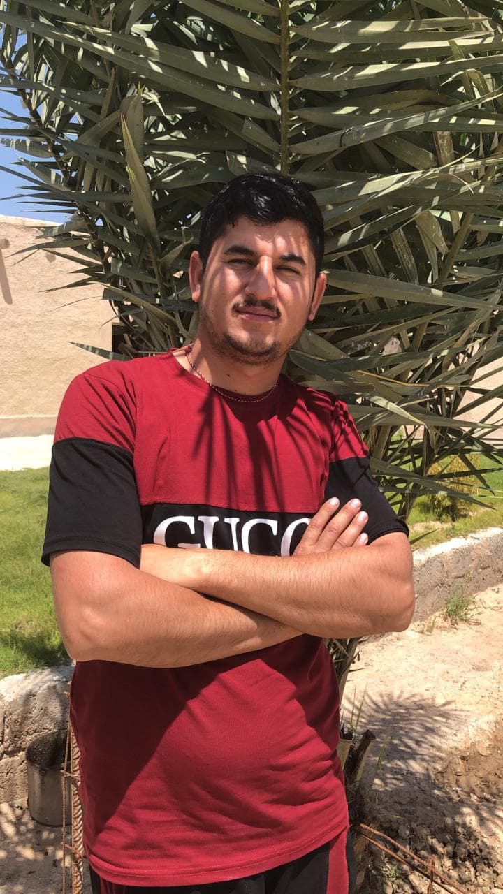 Portrait of man wearing red shirt and poses with arms crossed