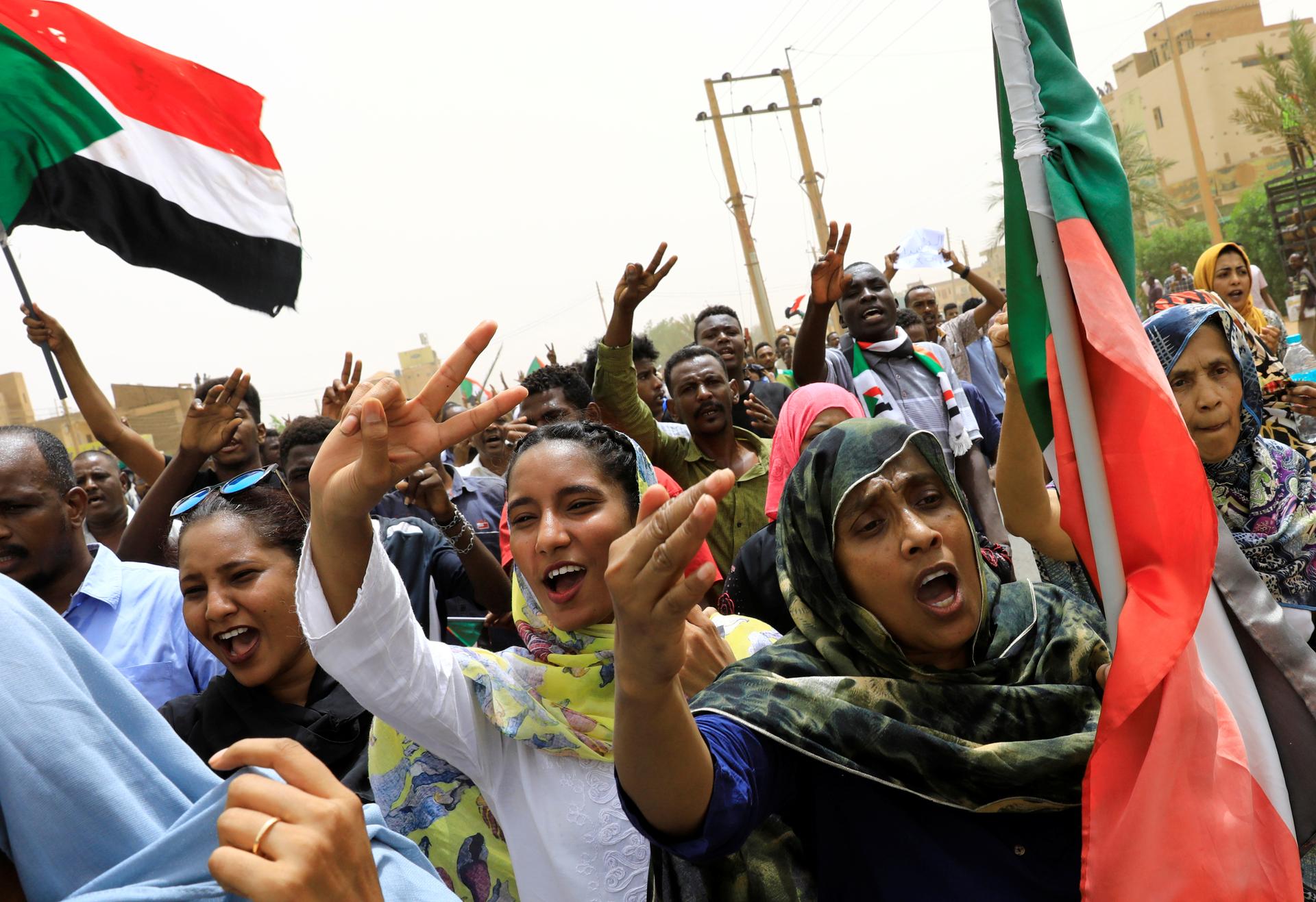 People shout slogans and hold the Sudanese flag as they march on the streets demanding the ruling military hand over to civilians during a demonstration in Khartoum, Sudan June 30, 2019. 