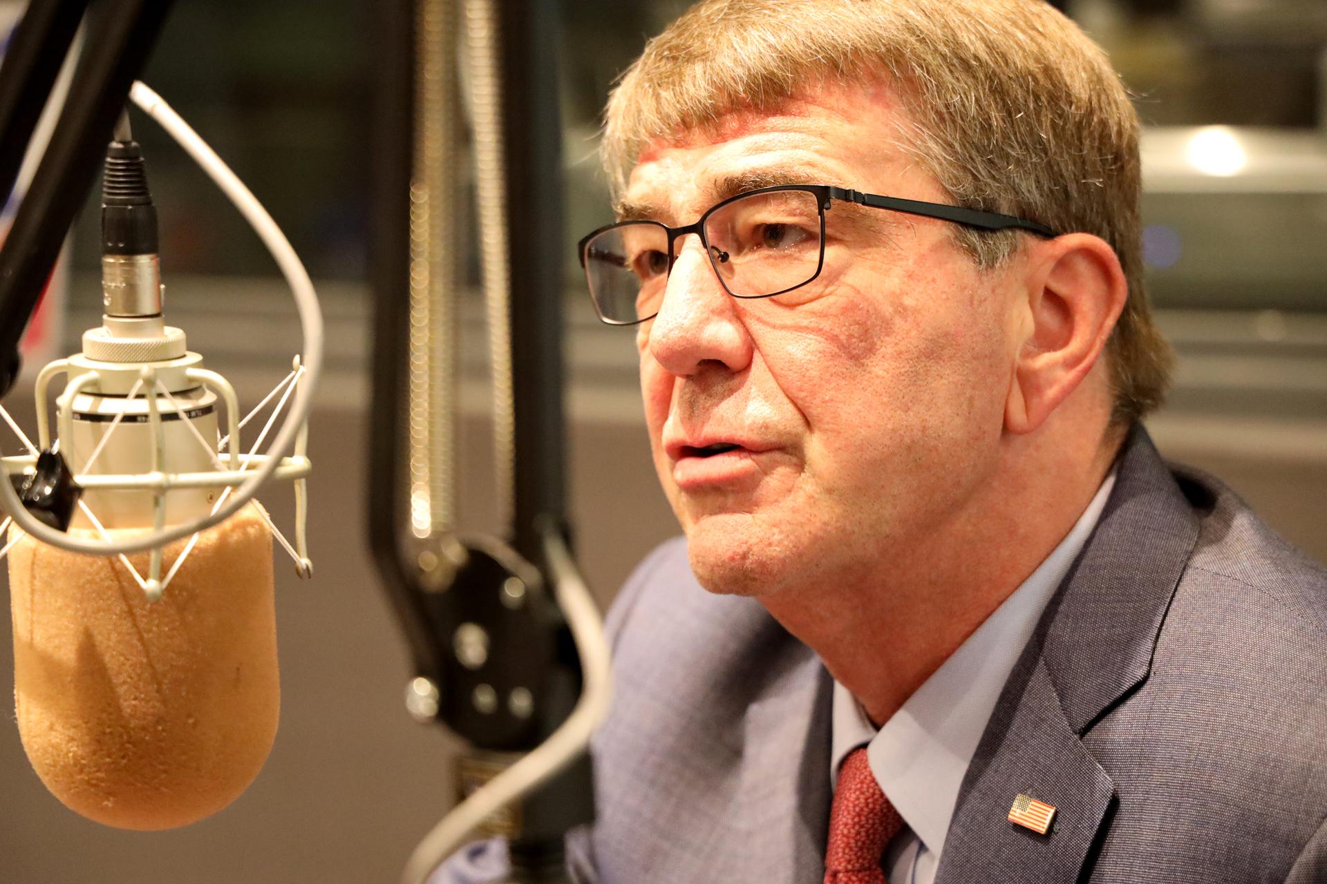 ash carter next to a microphone