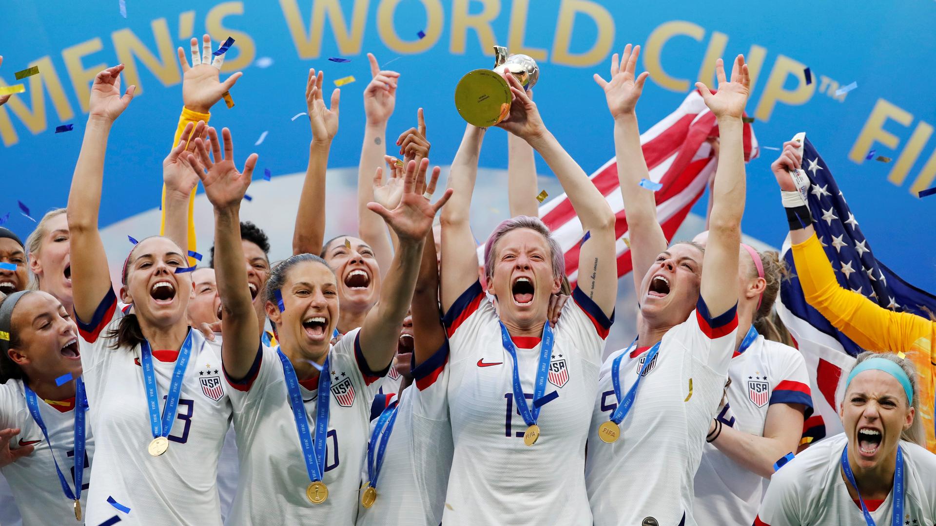 The US women's soccer team celebrates with the world cup trophy