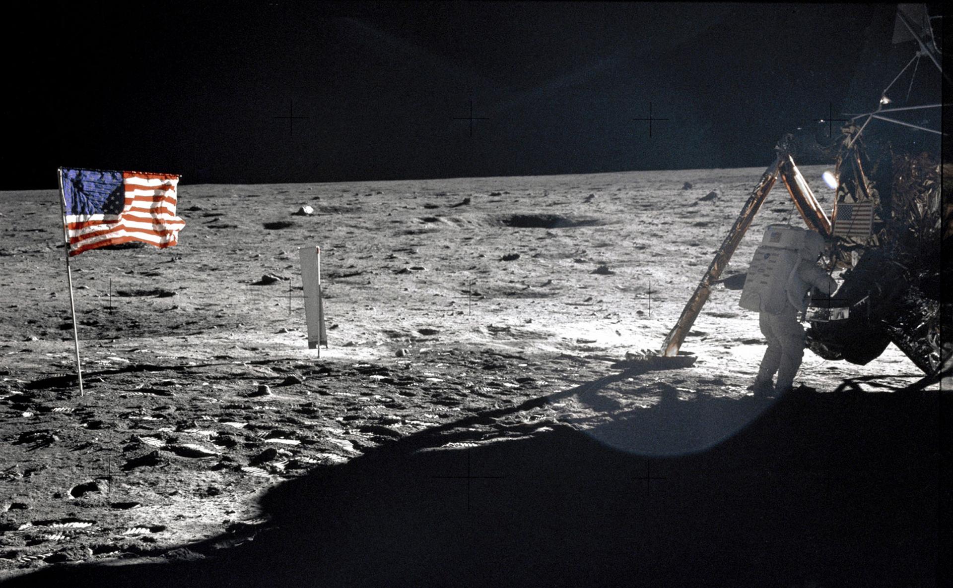 A US flag is shown on the moon adjacent to the Lunar Module.
