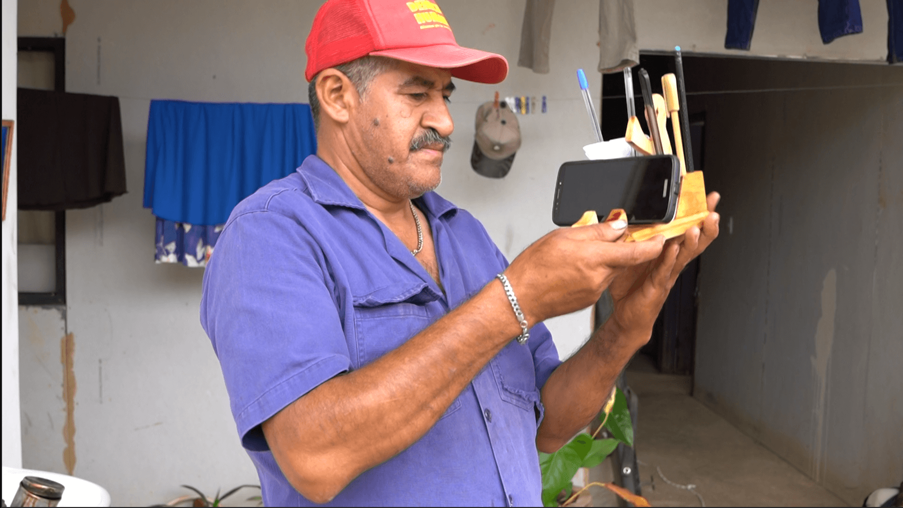 A man shows his pencil holder creation