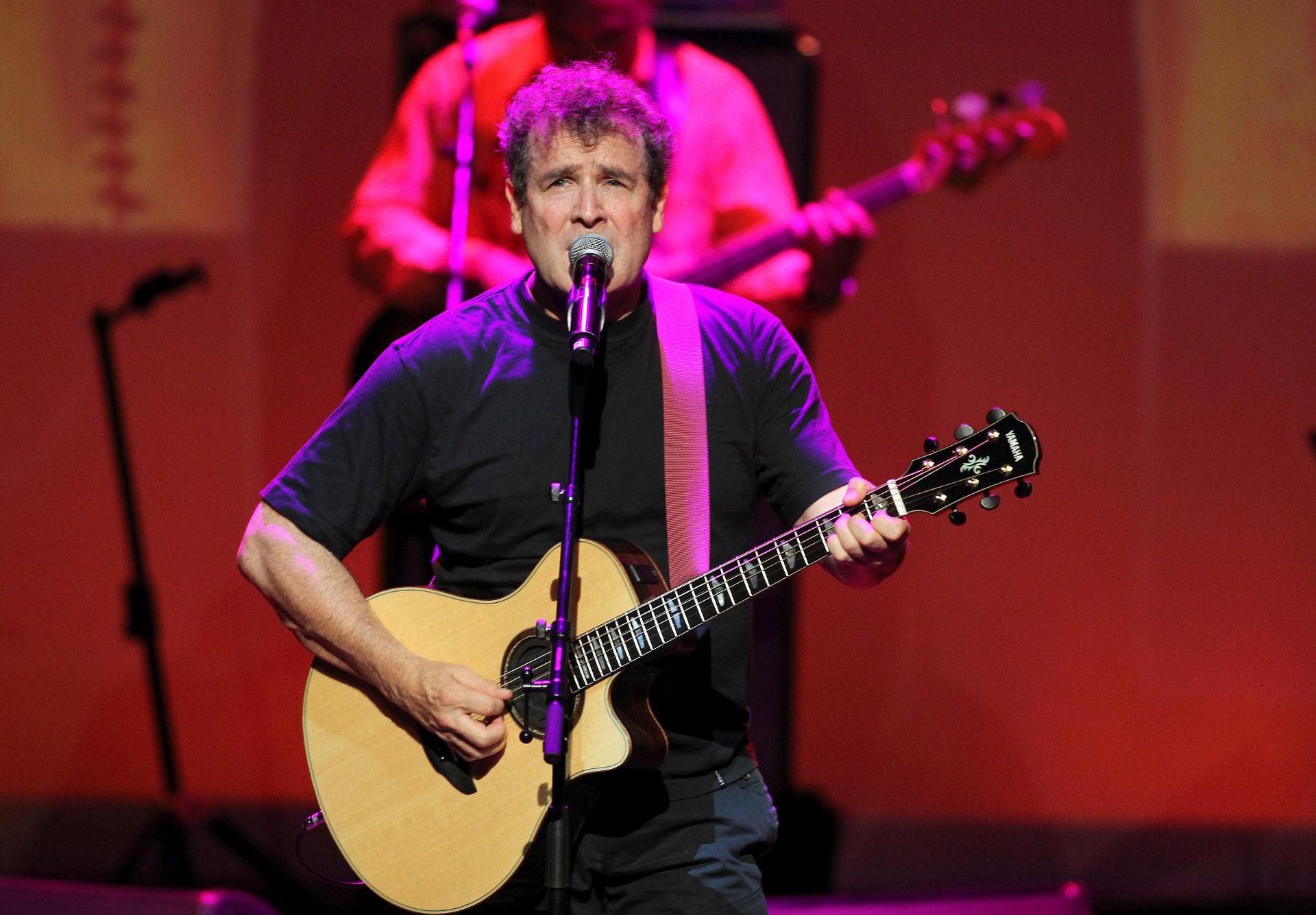 Singer Johnny Clegg performs on stage. 
