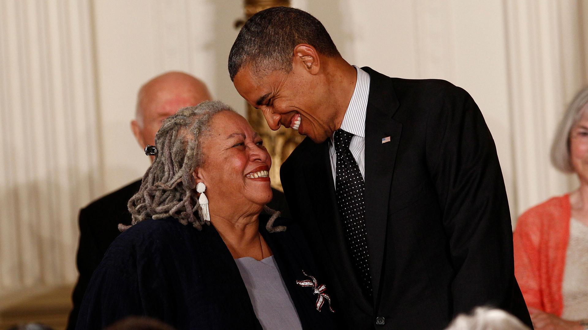 Writer Toni Morrison and Barack Obama smile at each other