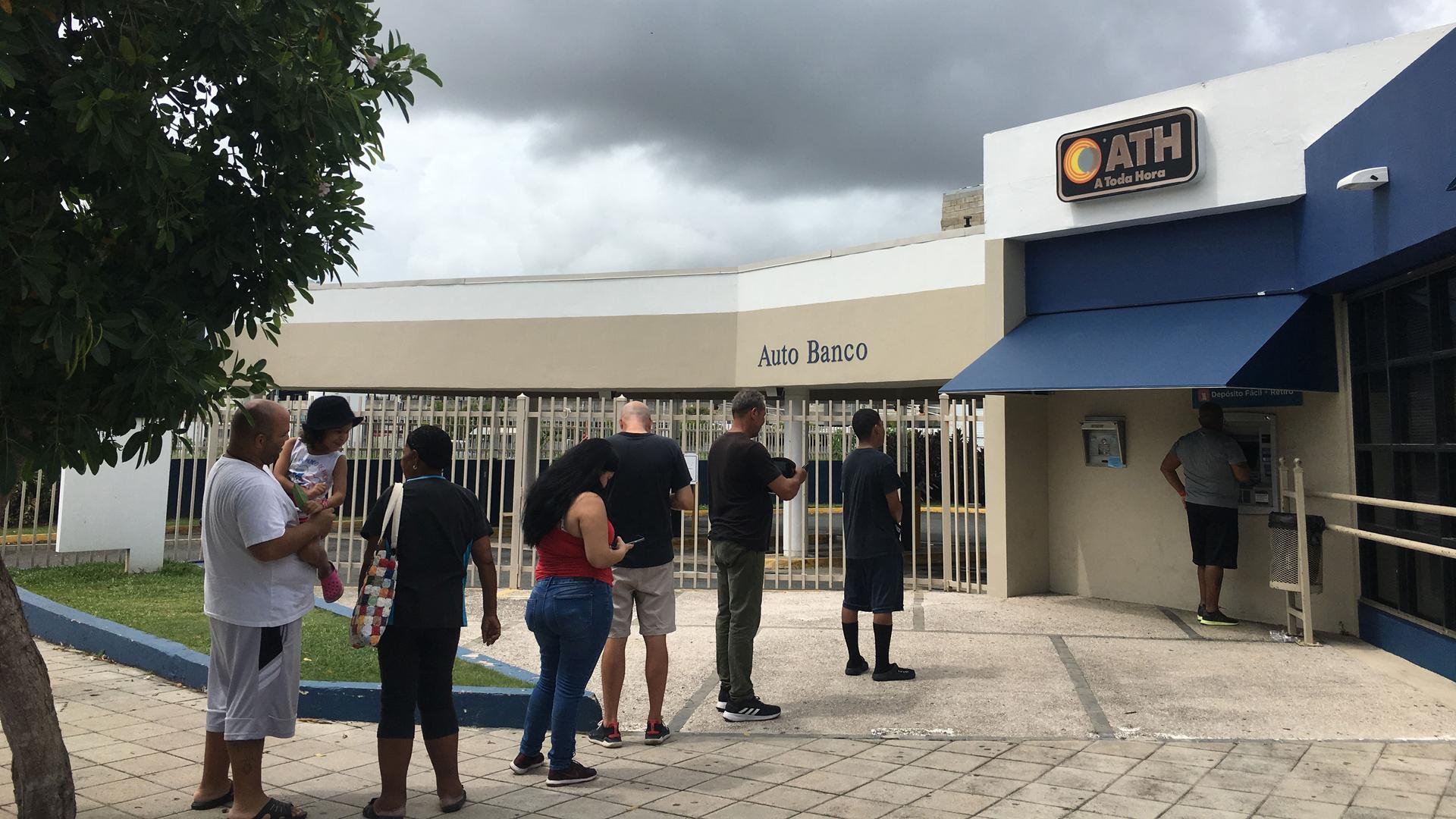 Puerto Ricans wait to get cash out of an ATM in San Juan ahead of Tropical Storm Dorian on Aug. 28, 2019.