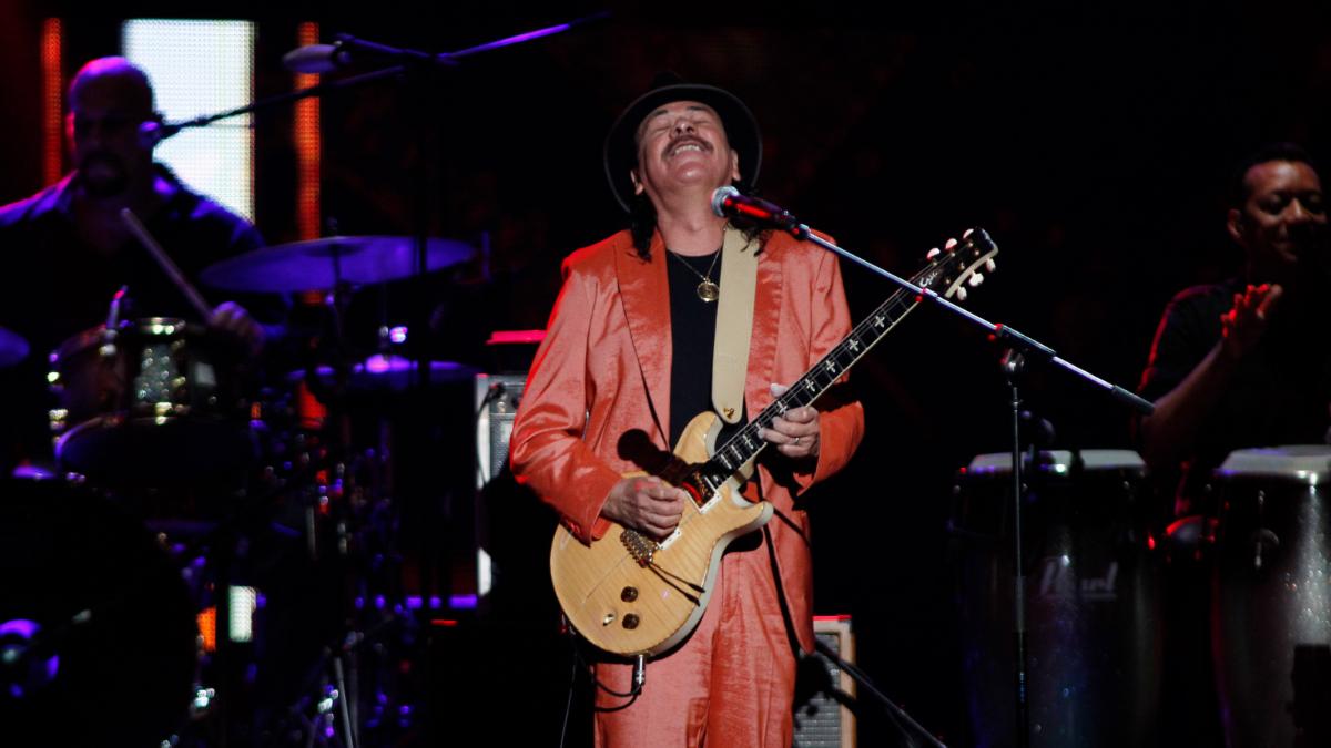 A man in a red suit plays the guitar