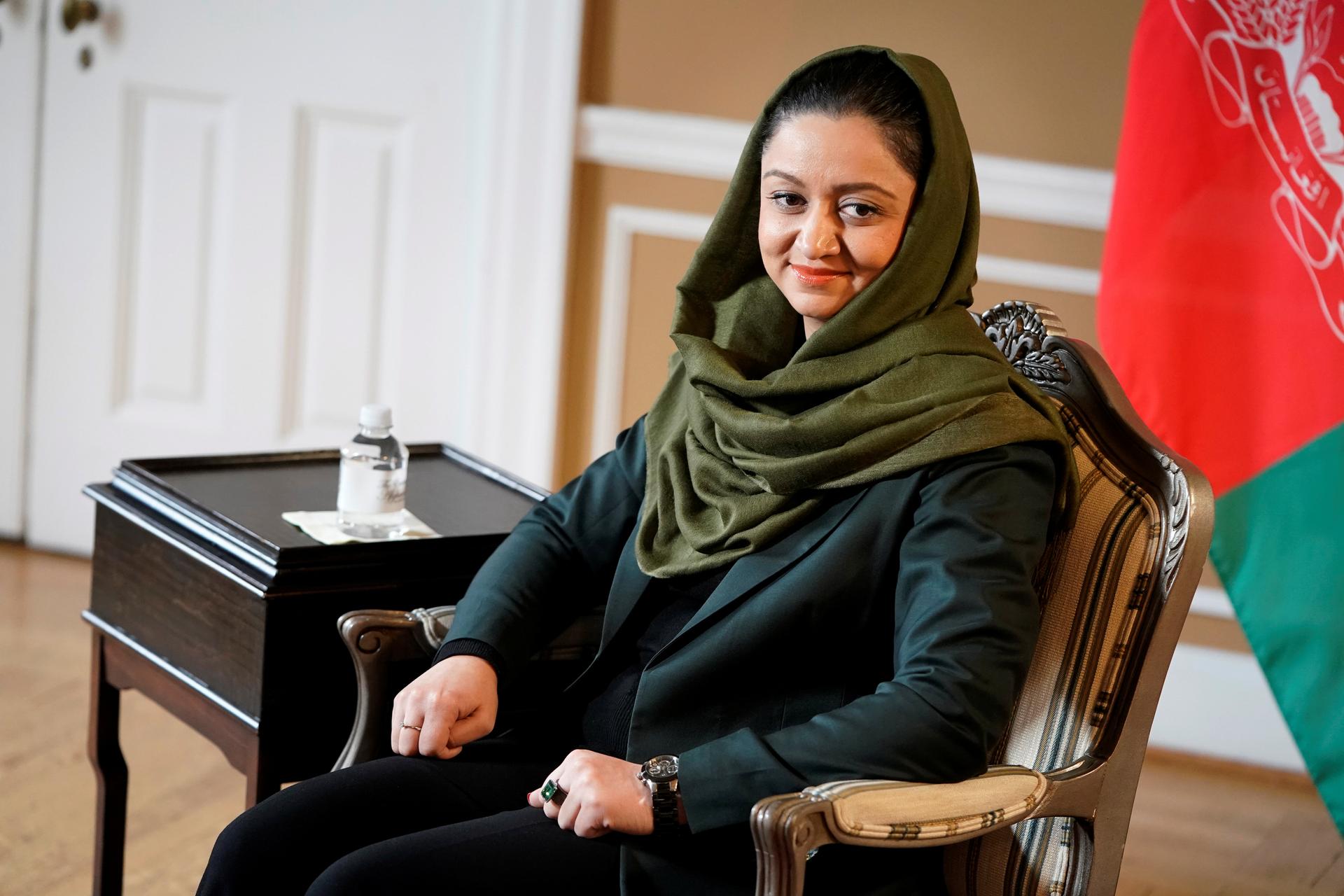 The Afghan ambassador to the US, Roya Rahmani, sitting in front of an Afghan flag. 