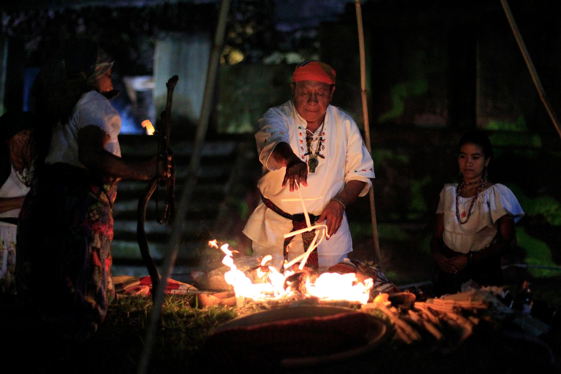 Mayans perform a fire ceremony at an archaeological site.
