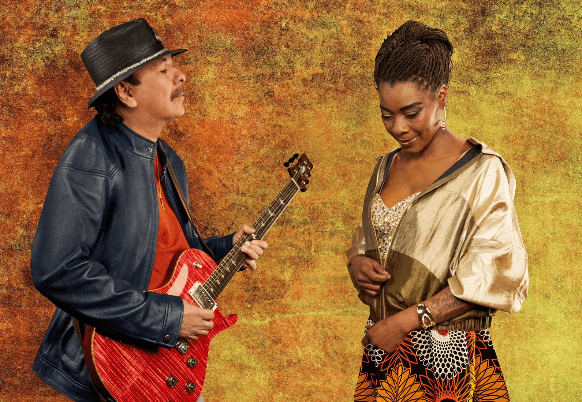 A man plays the guitar in front of a woman looking down to the floor.