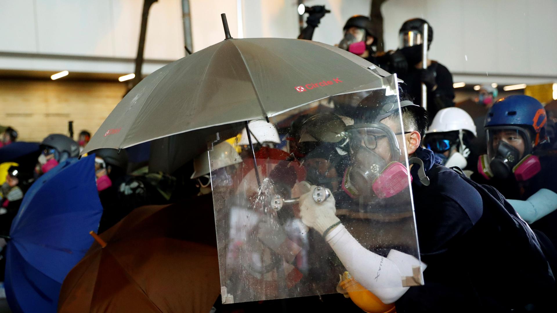 A demonstrator uses a makeshift shield to take cover during a protest in Hong Kong