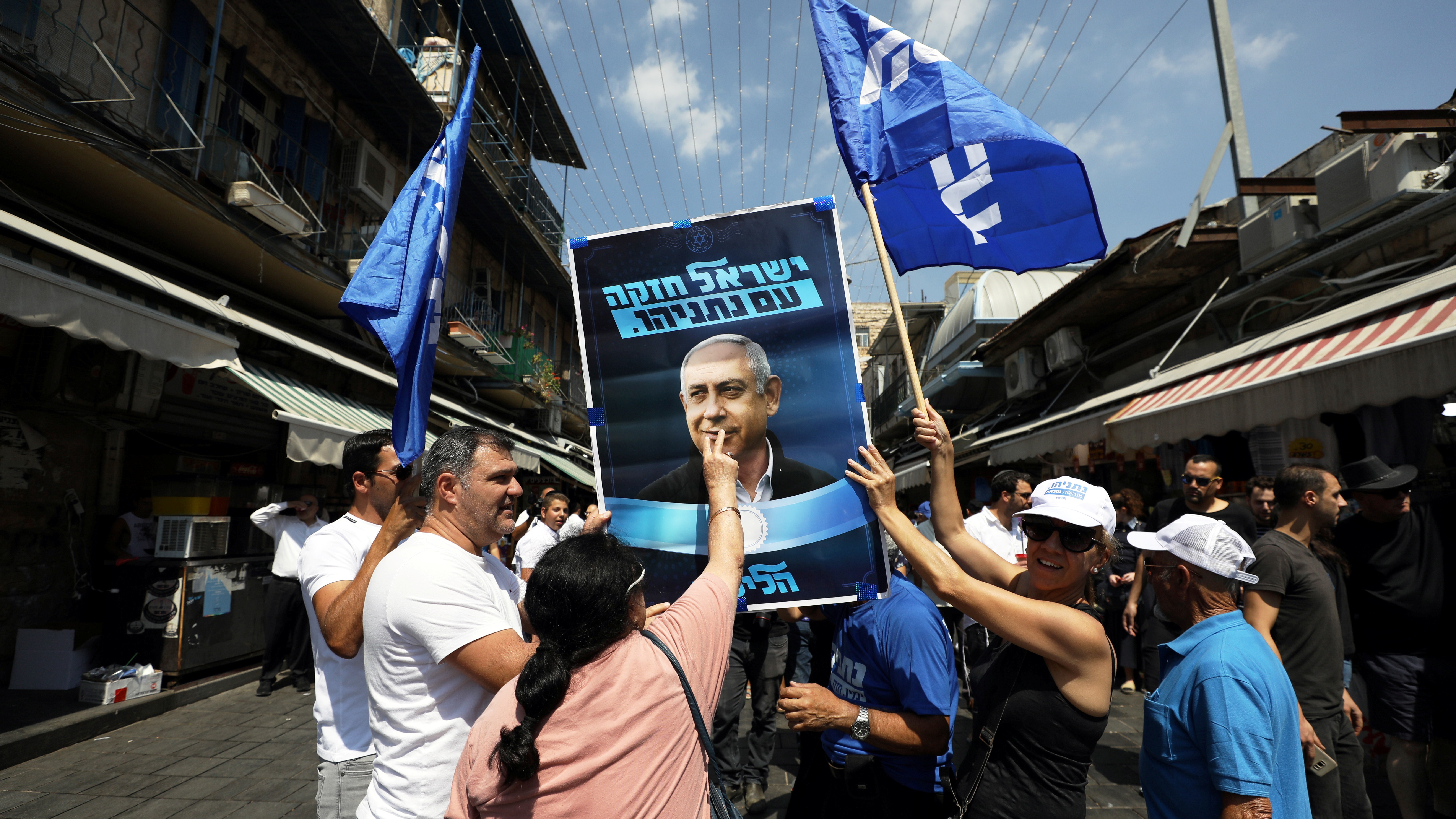 A supporter of the Israeli Likud party kisses an election campaign poster depicting Israel Prime minister Benjamin Netanyahu at the market in Jerusalem.
