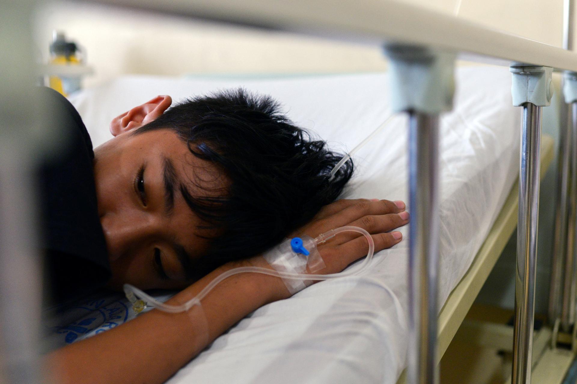 A boy lays down in a hospital bed.