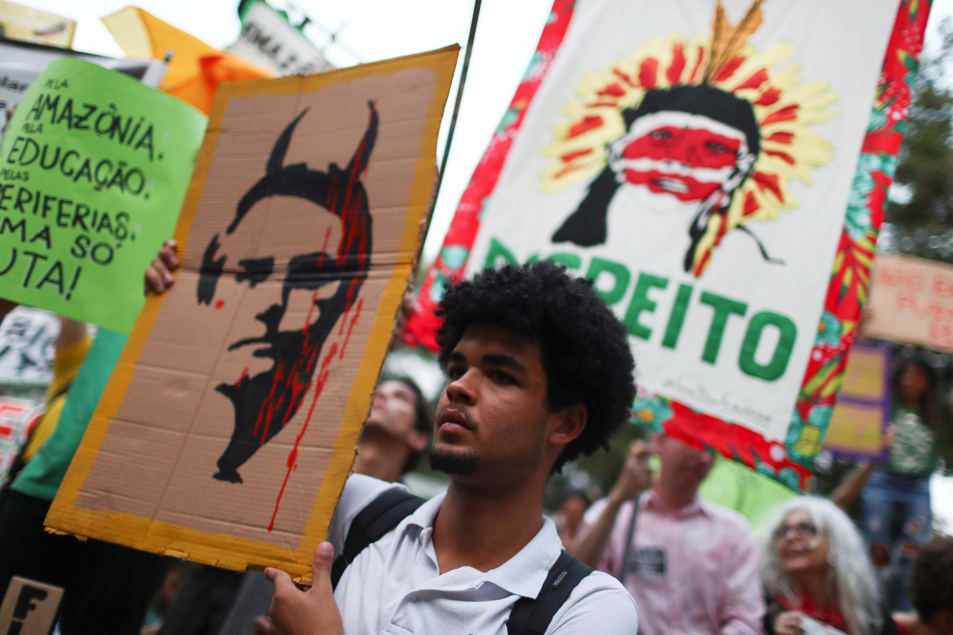 A person holds a placard with a drawing depicting Brazil's President Bolsonaro with horns during a Global Climate Strike rally in Rio de Janeiro