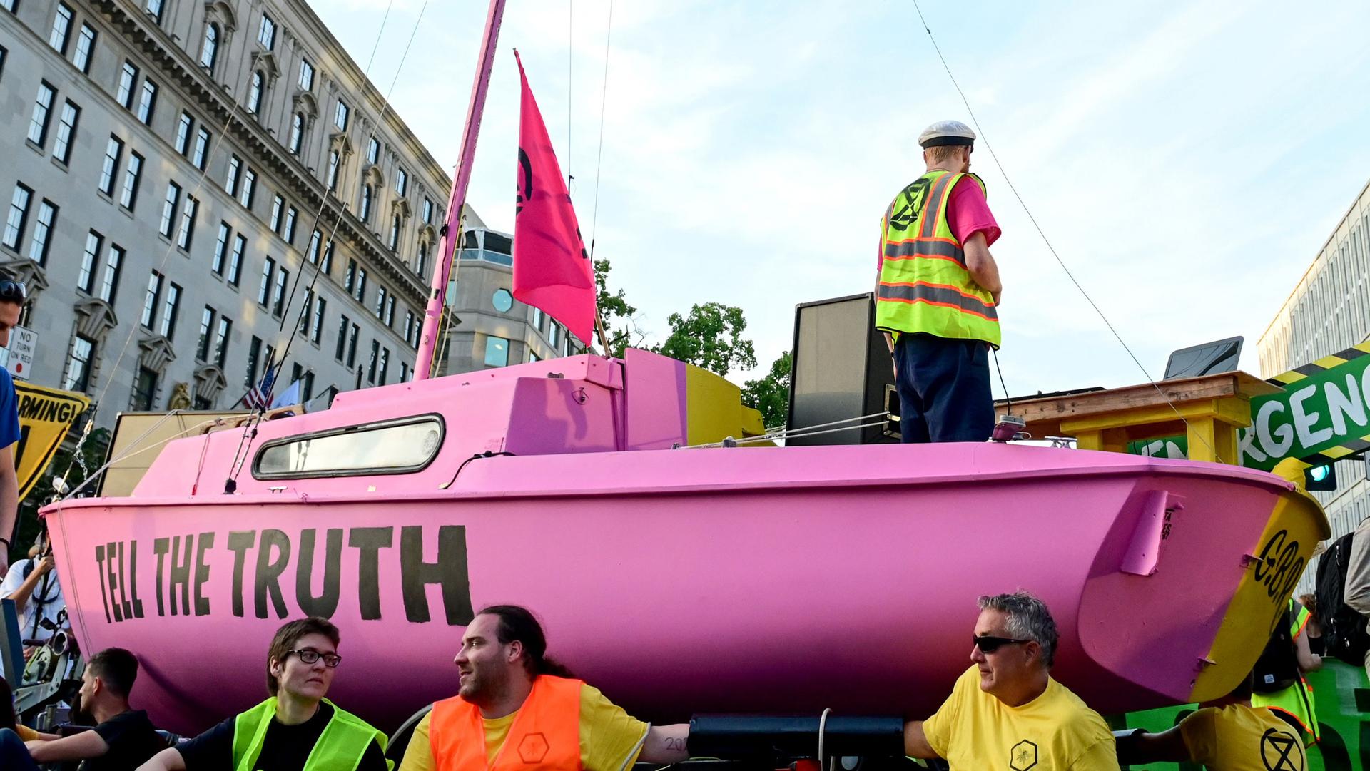 A sailboat is shown painted pink with the words, "Tell the Truth," written on the side.