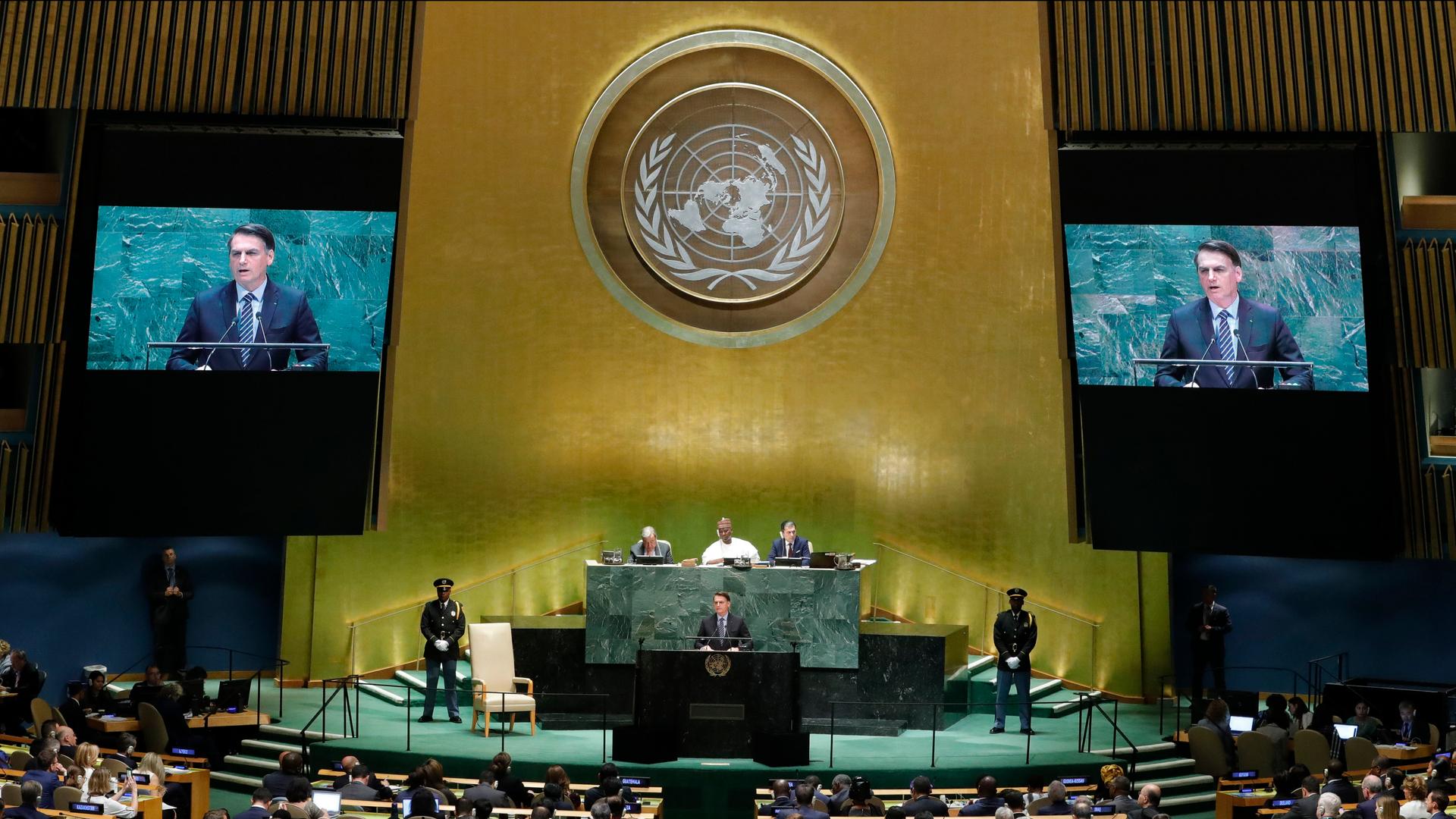 A man at a podium under the UN symbol