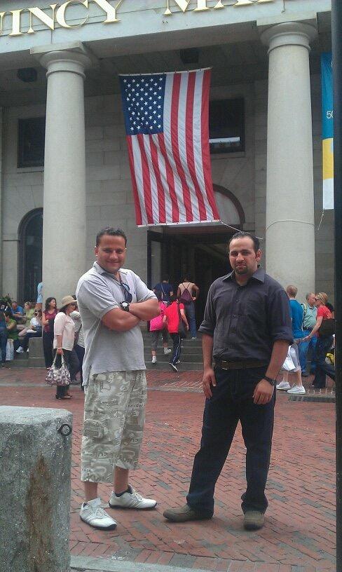Two men meet underneath a US flag