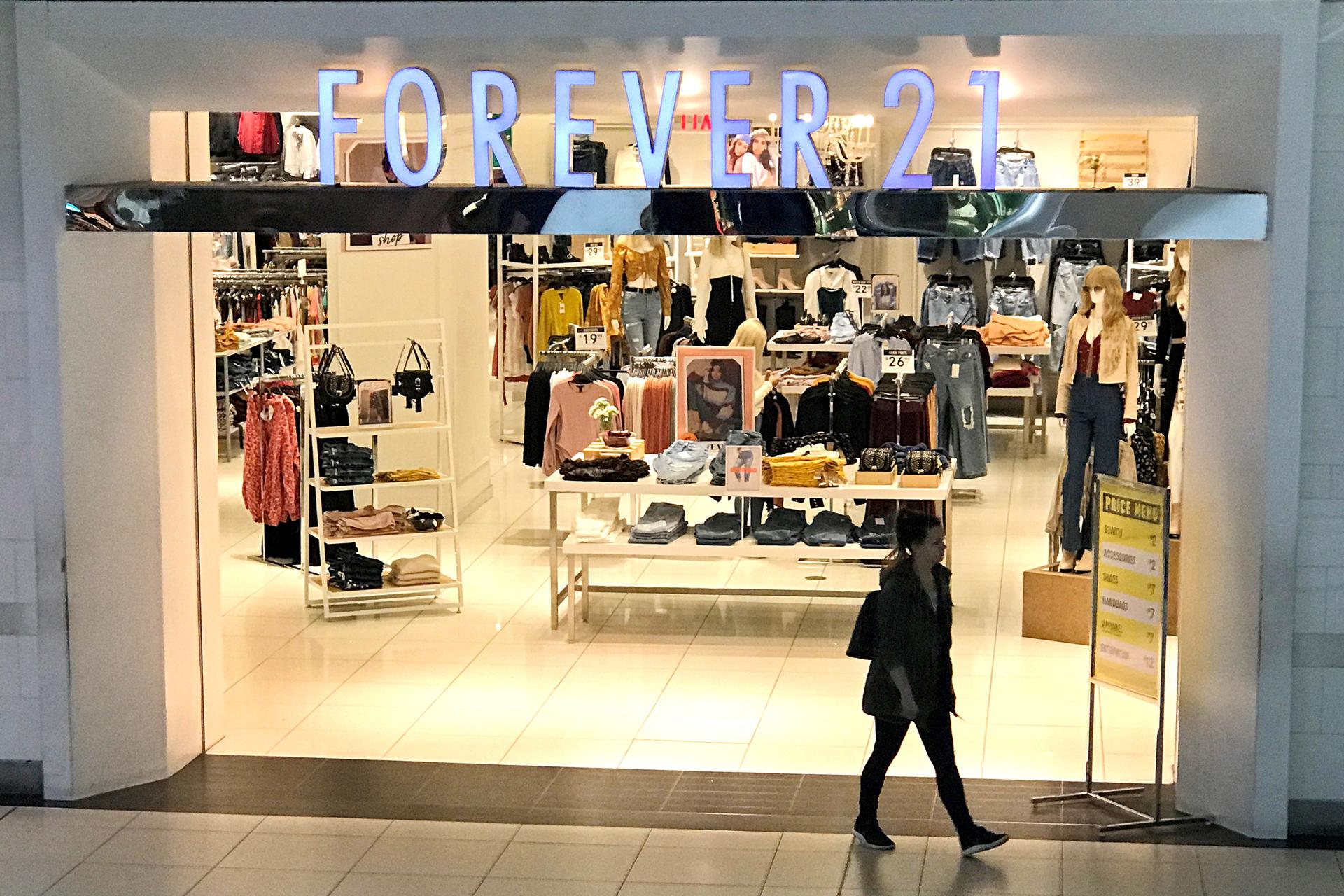 A woman walks in front of the store Forever 21.