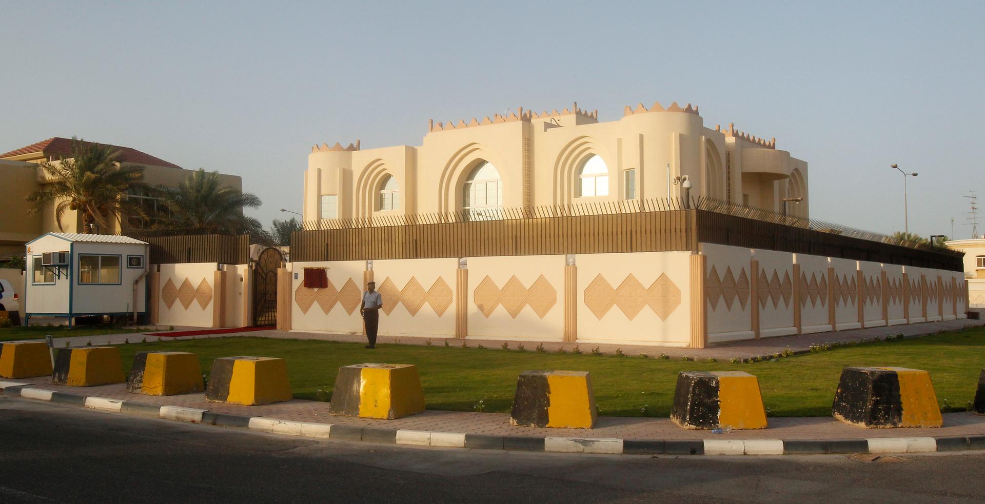 A picture of a tan building with barriers 