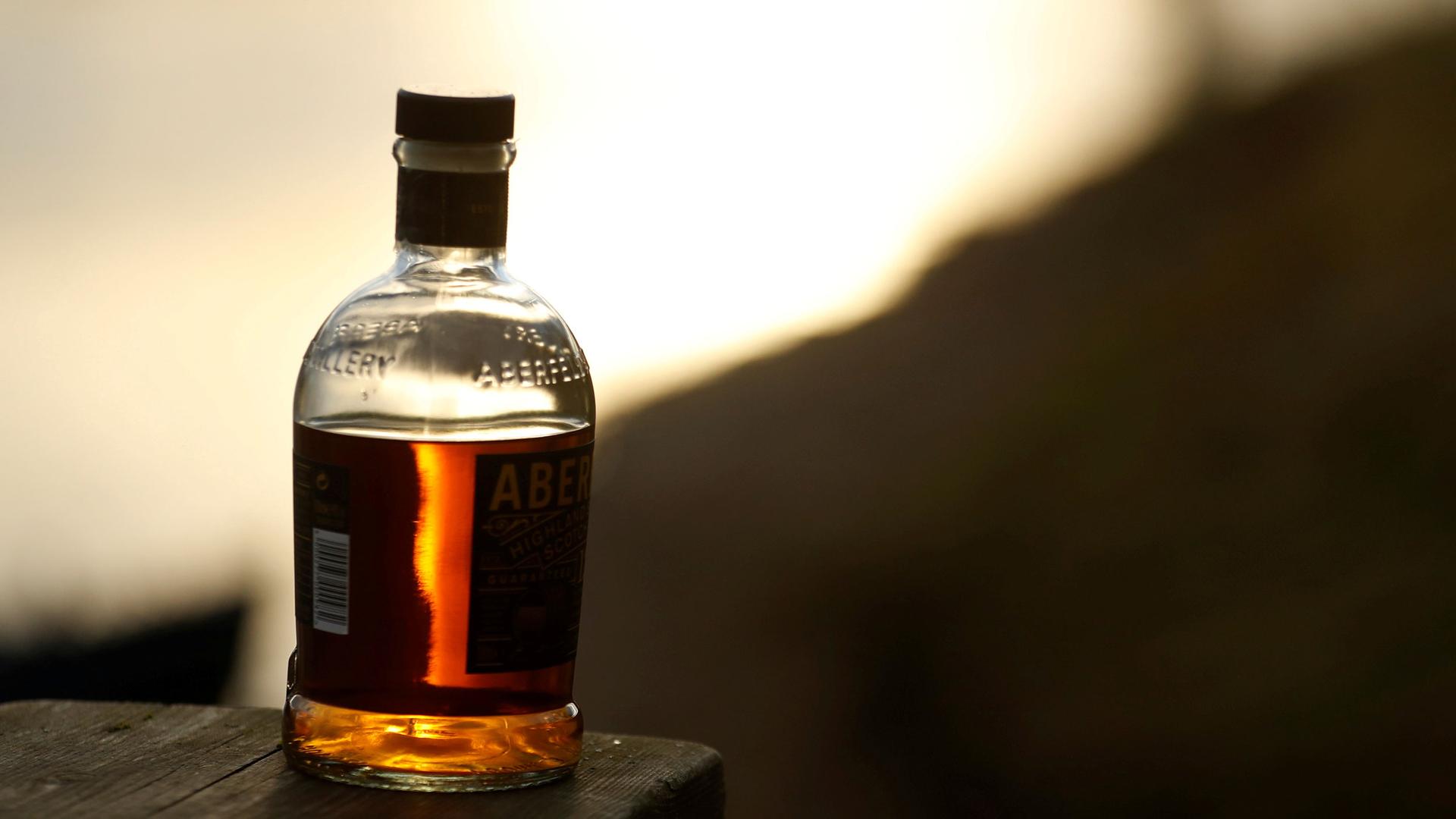 A bottle of whisky is left on a bank.