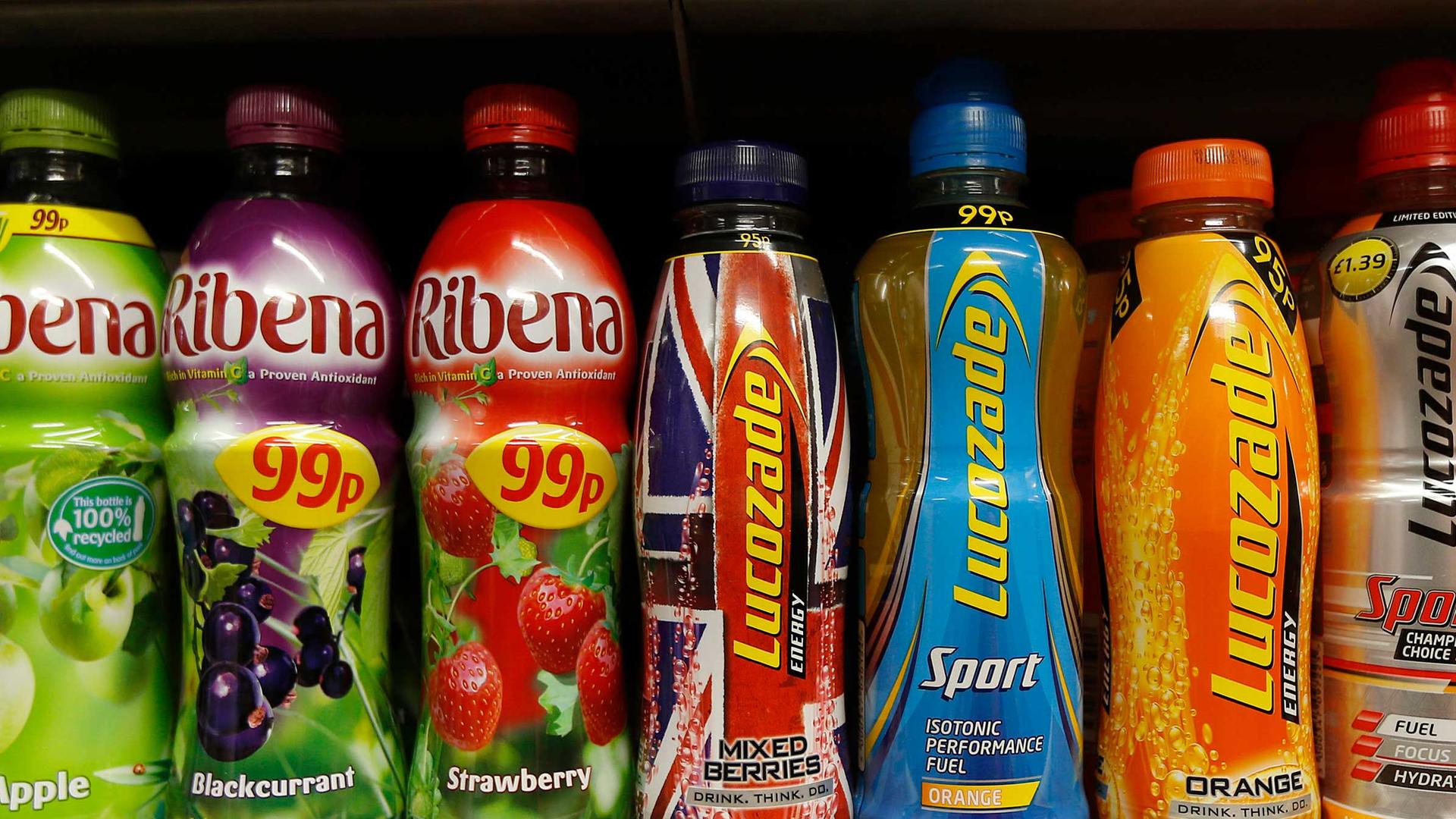 Sweetened juices and sports drinks in bottles are lined up in a row