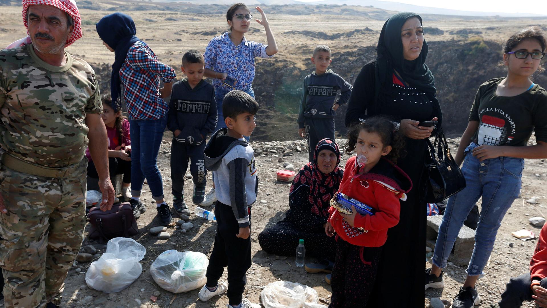 Displaced Kurds stuck at a border after a Turkish offensive in northeastern Syria, wait to try cross to the Iraqi side, at the Semalka crossing, next Derik city, Syria, on Oct. 21, 2019.
