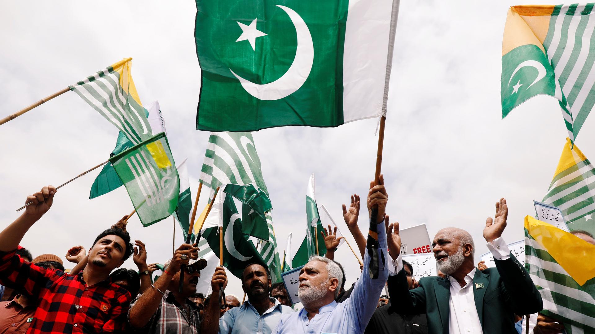 People carry Pakistan's and Azad Kashmir's green flags and chant slogans to express solidarity with the people of Kashmir, in Karachi, Pakistan, August 30, 2019.