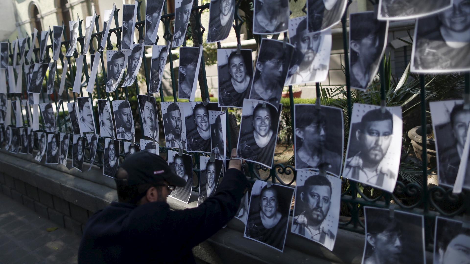 A man hangs images of murdered journalists during a demonstration against the murder of a journalist Anabel Flores outside the Government of Veracruz building in Mexico City, February 11, 2016.
