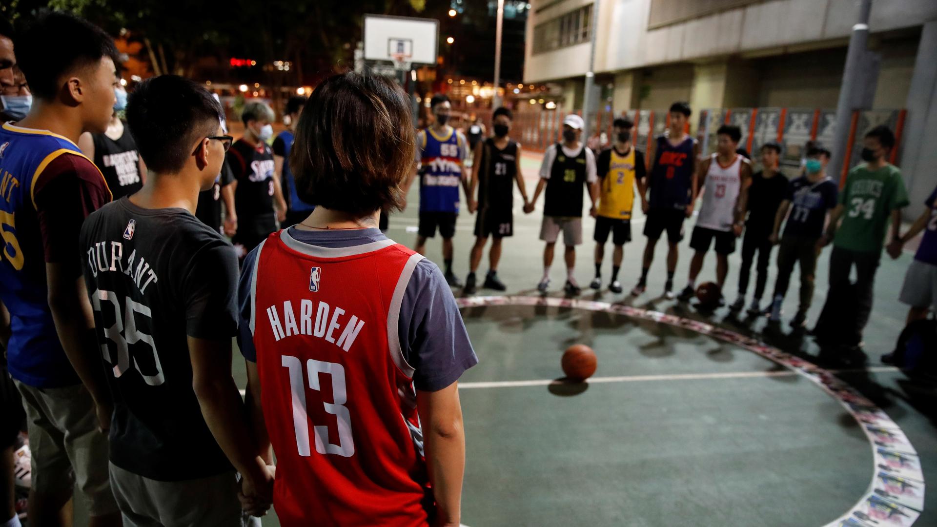 A ring of protesters in basketball uniforms