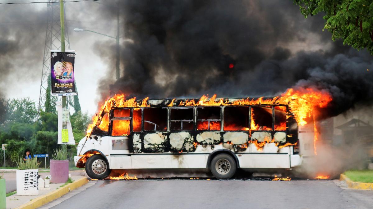 a white bus is engulfed in flames.