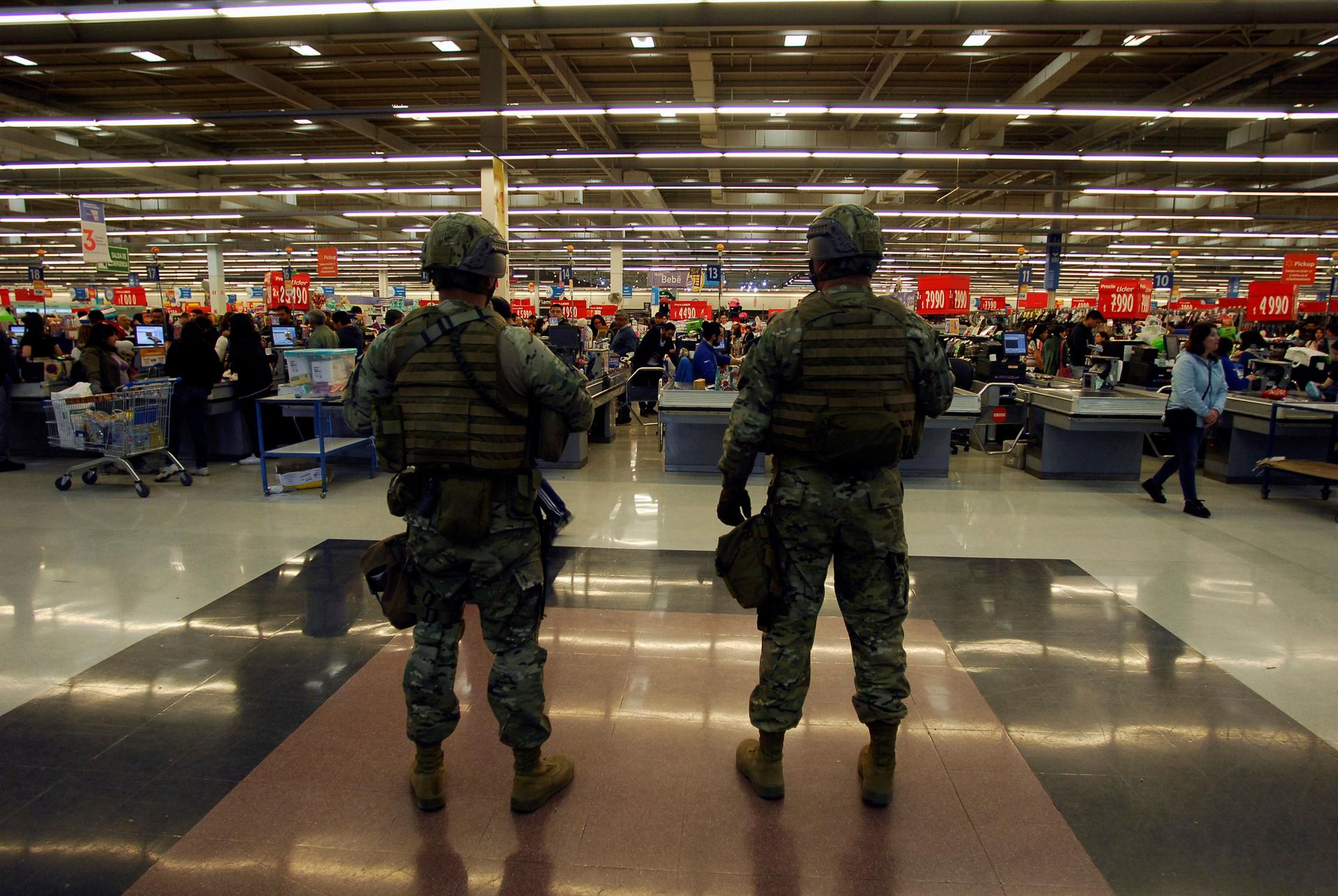 Soldiers are shown stand guard wearing full combat armor and helmets with supermarket checkout lines in the background.